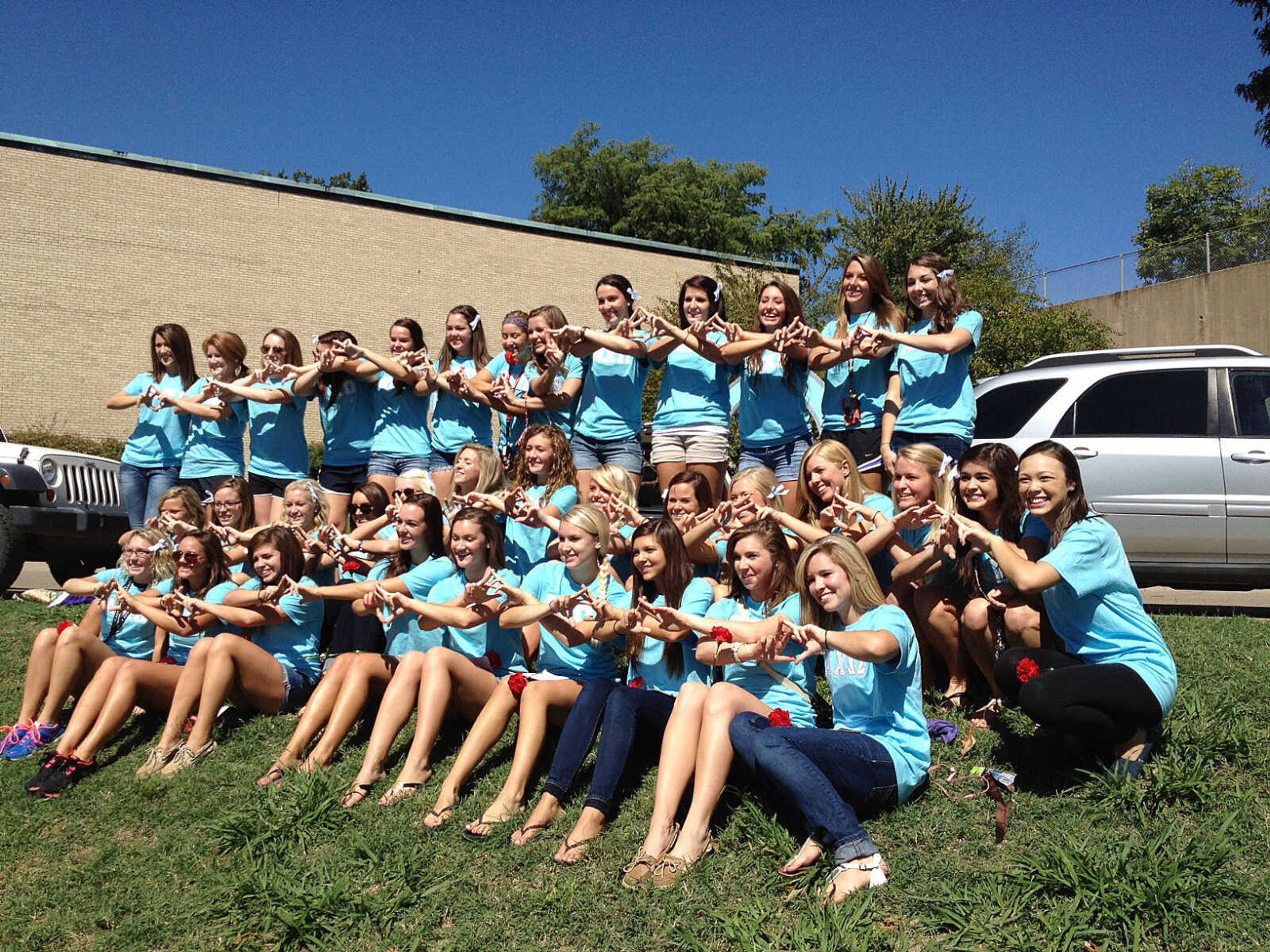Women from Alpha Chi Omega pose for a group picture at Bid Day on Sunday. Most of the sororities and fraternities had group pictures taken. Photo by Lauren Fox
