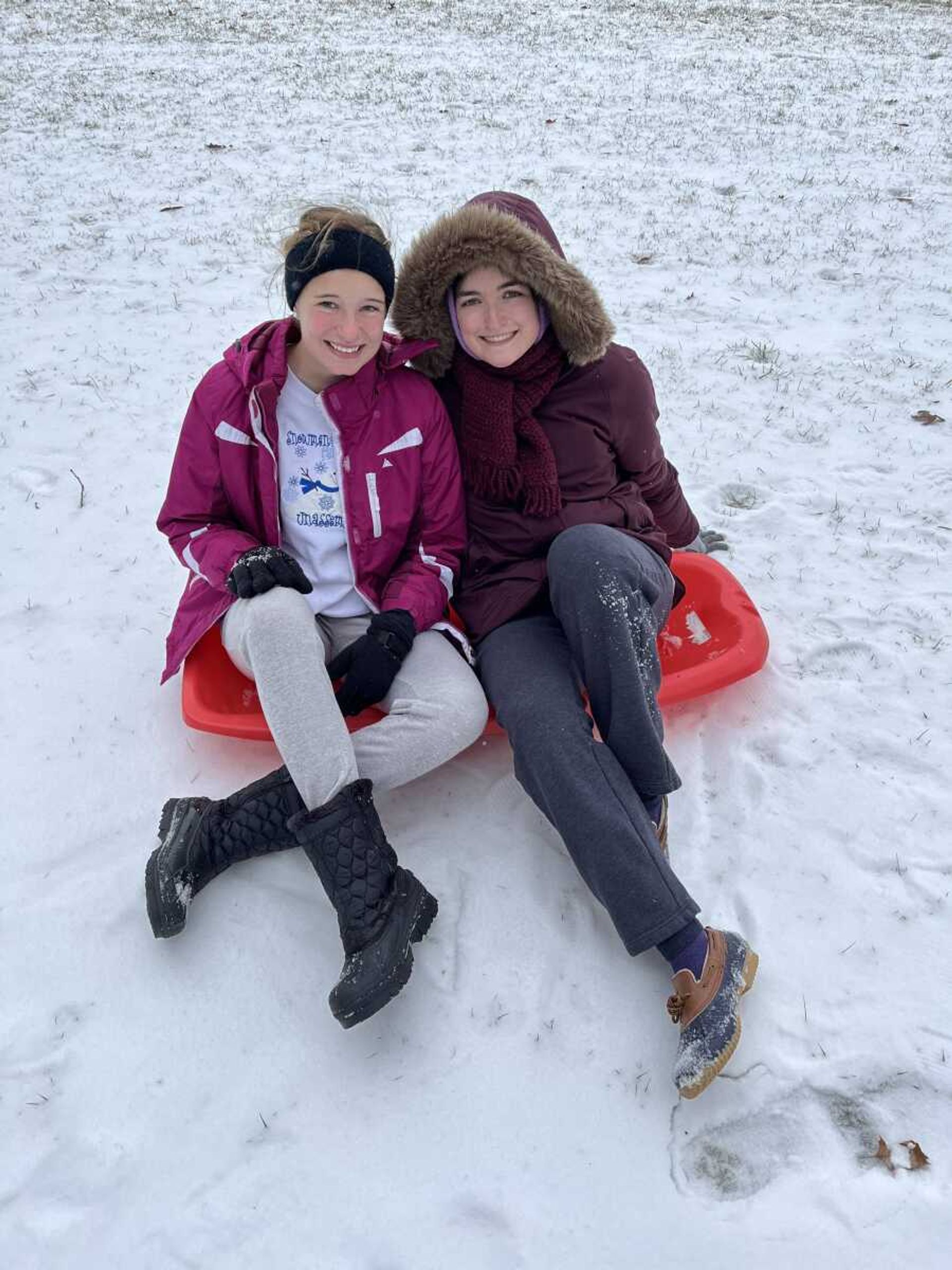 LaFerla Hall Resident Assistants Hannah Kroencke and Emily Bloodworth pose on a sled. Many students enjoyed their snow days by sledding down the campus' many hills. 
