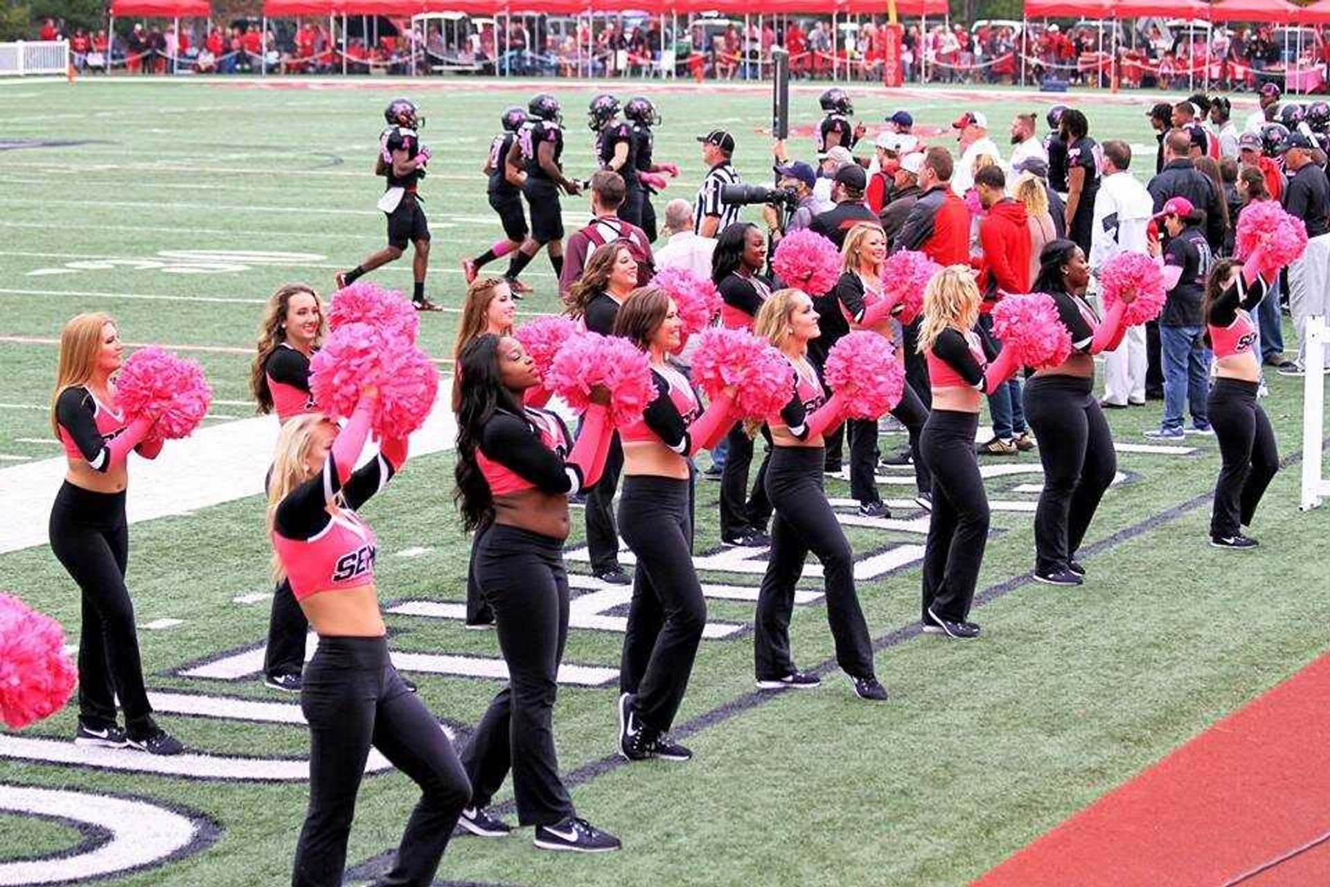 Southeast Sundancers welcome the football team on the field during the annual Pink Up Cape game on Nov. 4 against UT Martin.