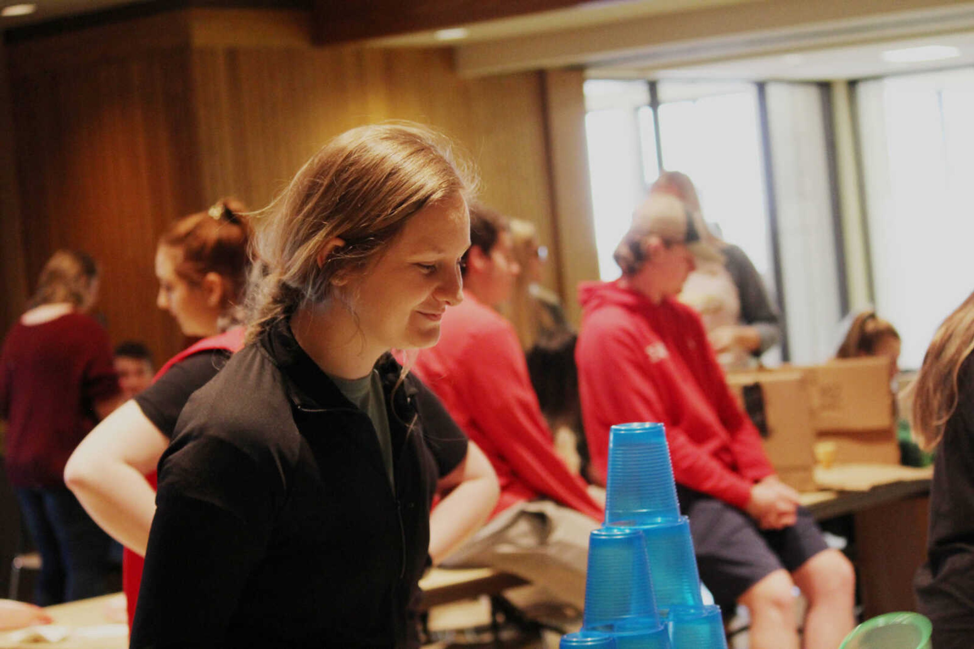 Johanna Franke watches as her little sister test her own skills in the cup stacking game.