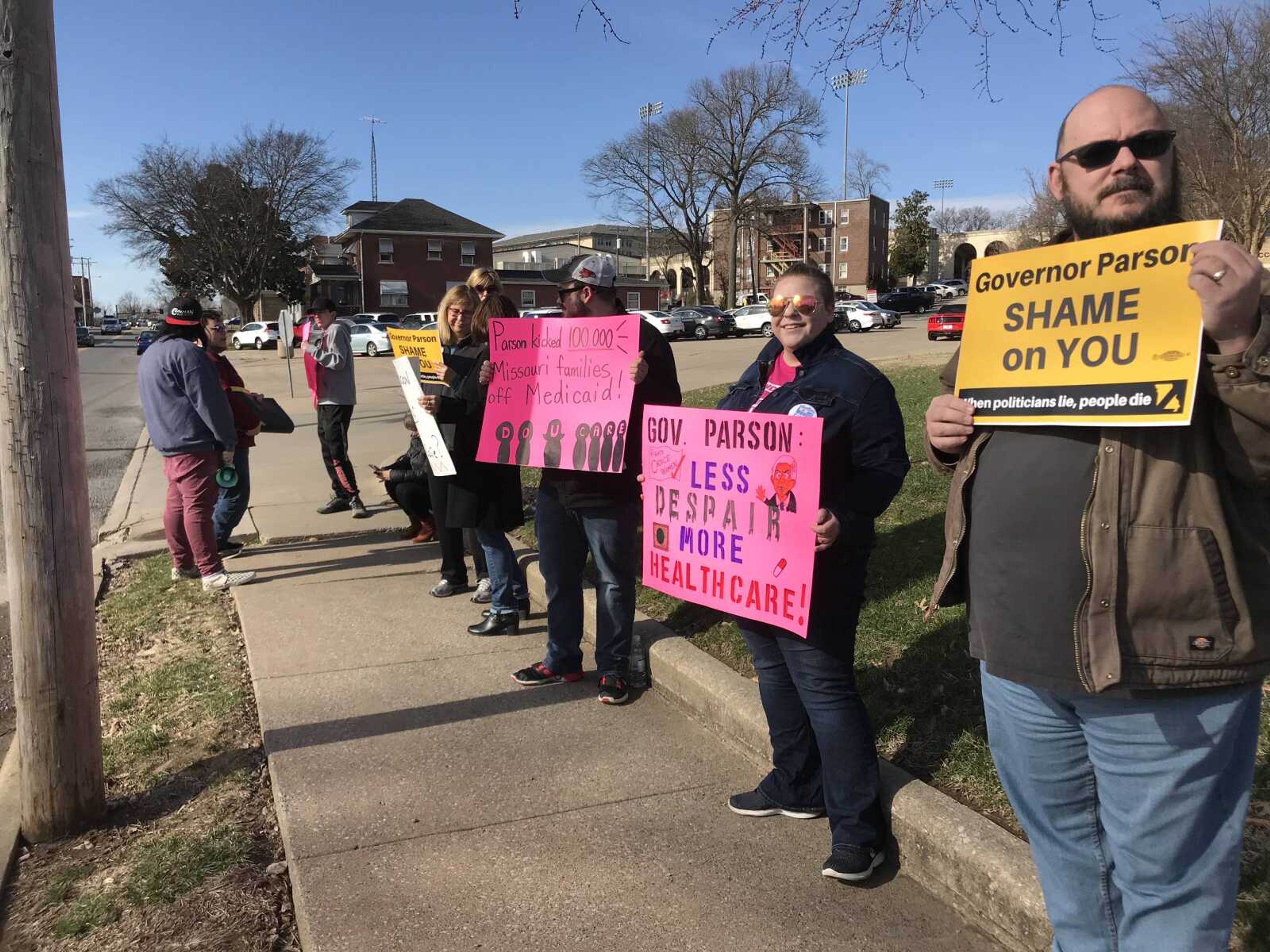 A group of constituents hold signs to demonstrate opposition with recent political decisions on Broadway outside the Wehking Alumni Center on Southeast's campus Wednesday, Feb. 19.