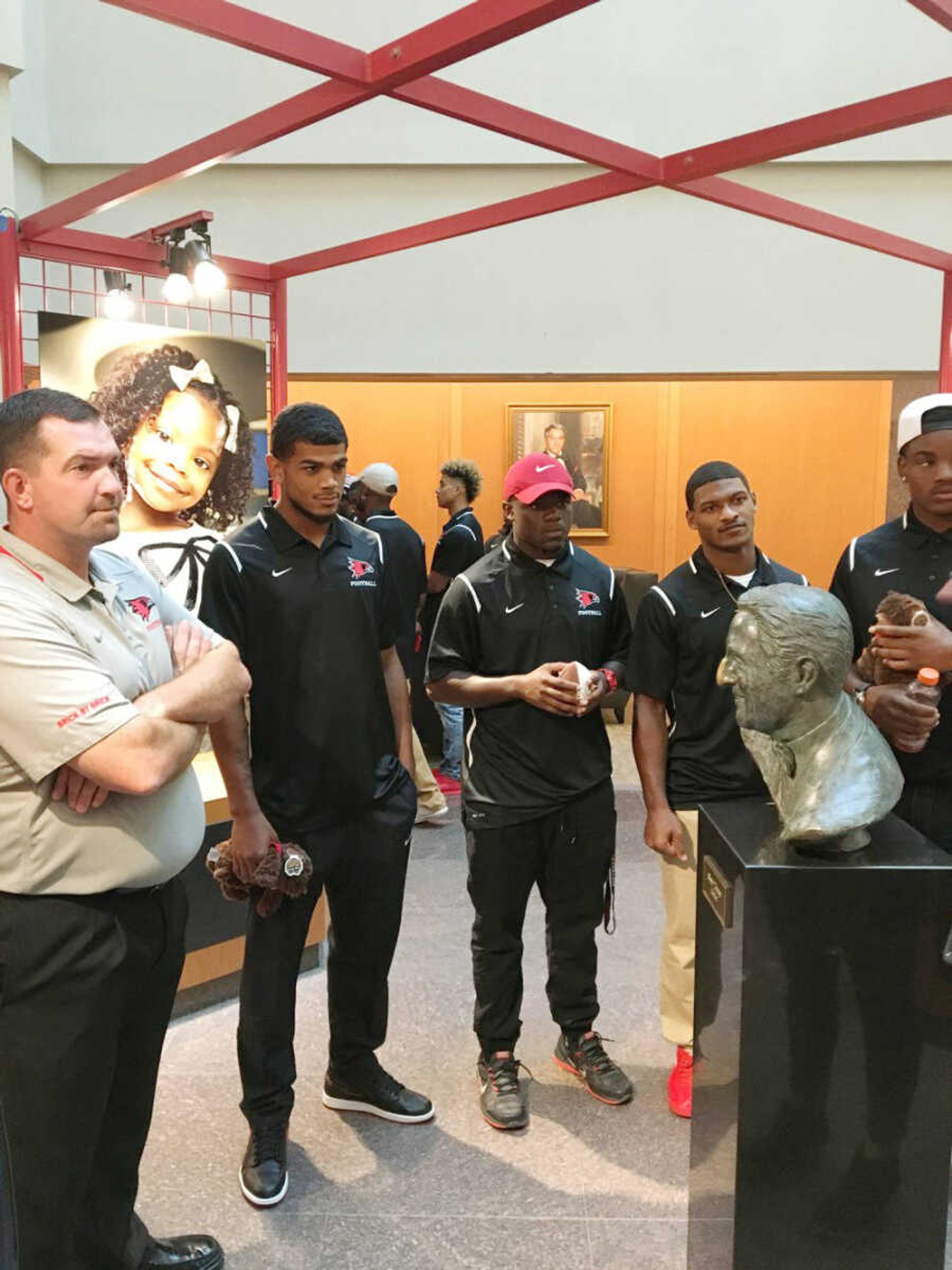 From left to right, coach Tom Matukewicz, junior running back Chase Abbington, sophomore running back Eddie Morris and junior running back Will Young listen to directions while visiting St. Jude children's hospital on Sept. 3. Submitted photo