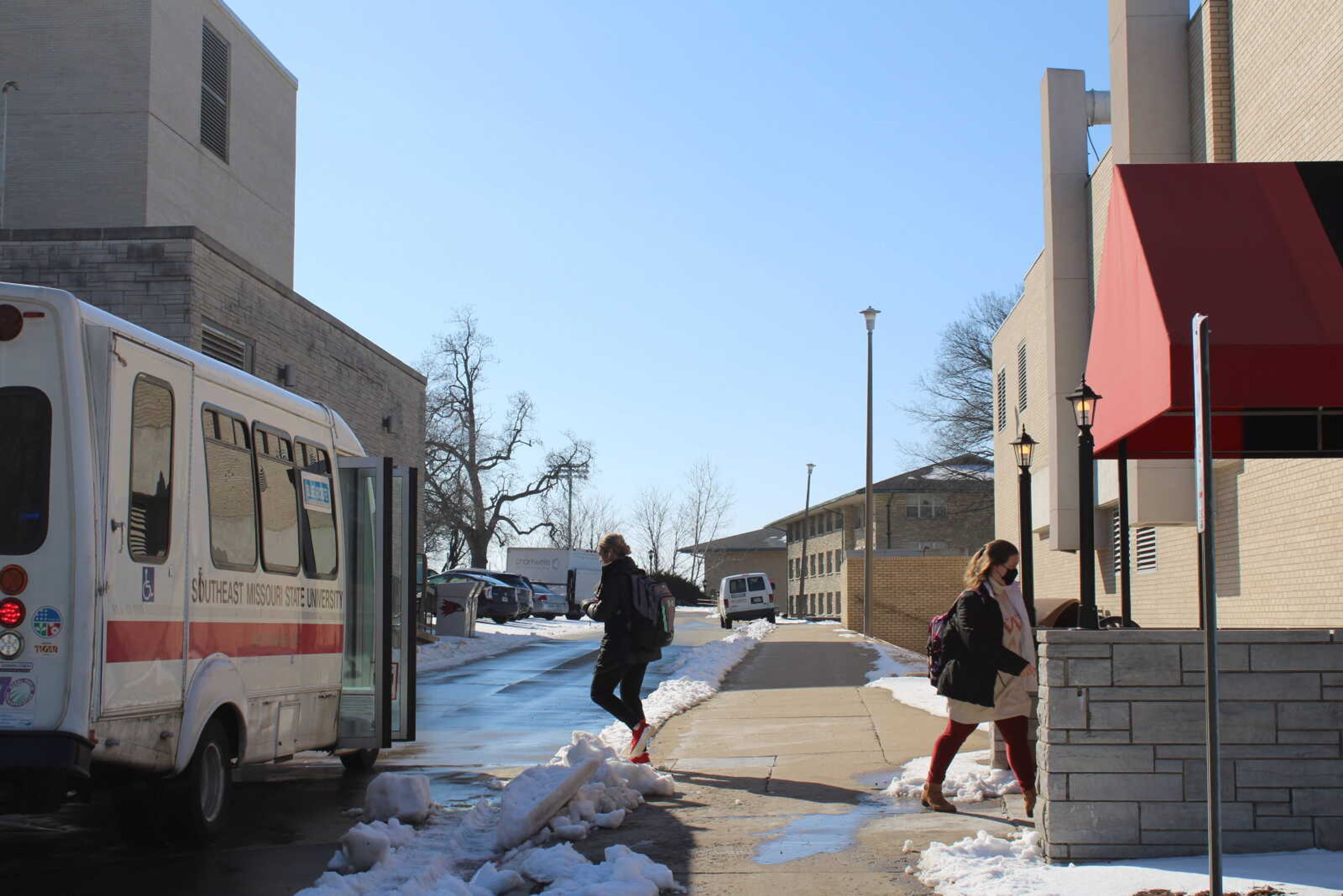 Students board and depart from the blue shuttle bus outside of Starbucks. With the shuttle tracking service down, students have relied on the shuttle bus schedules. 
