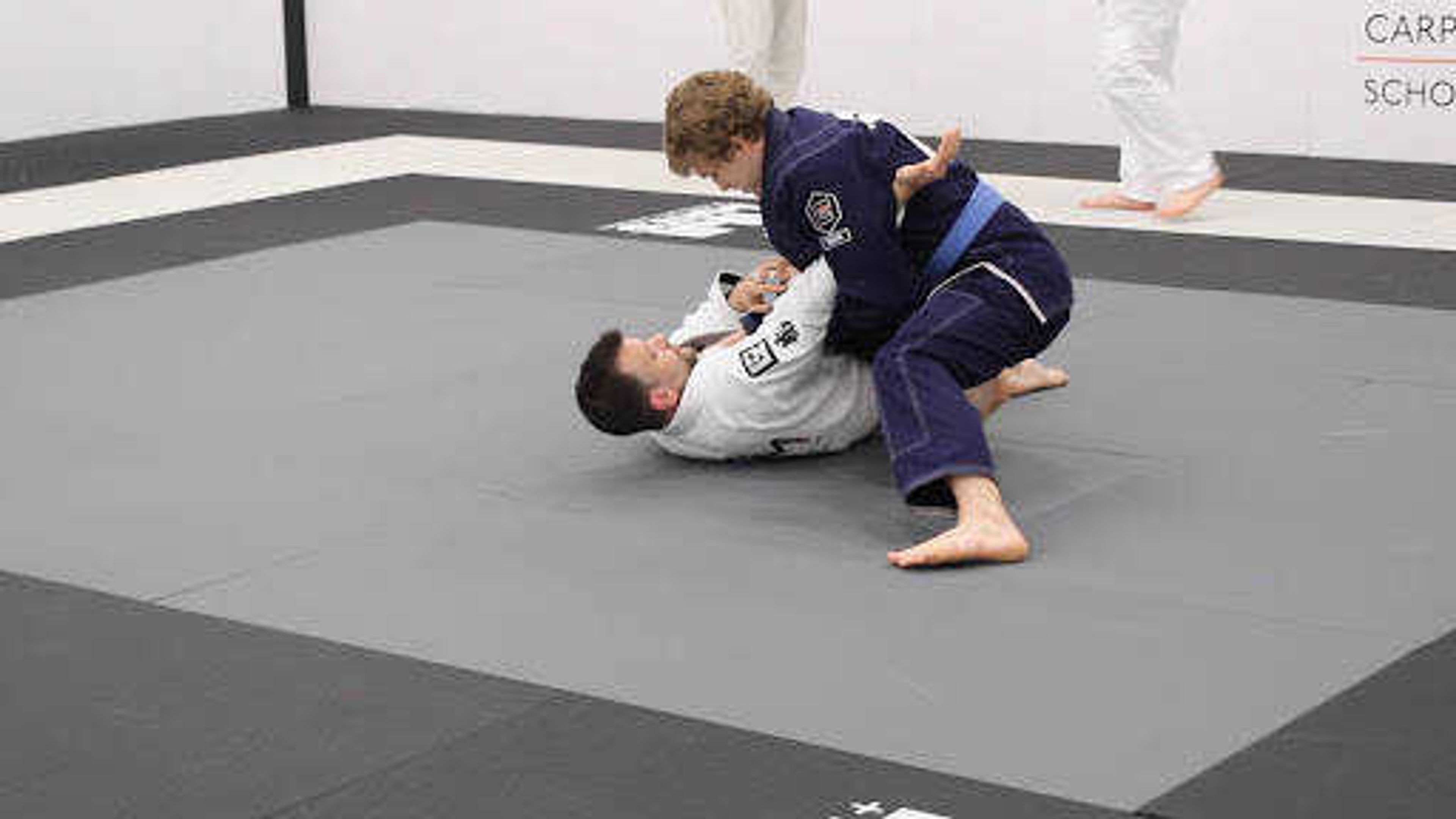 Preston Holifield and instructor John Dudley work on an arm bar technique during class at the Carpe Momentum School of Jiu Jitsu on February 19th.