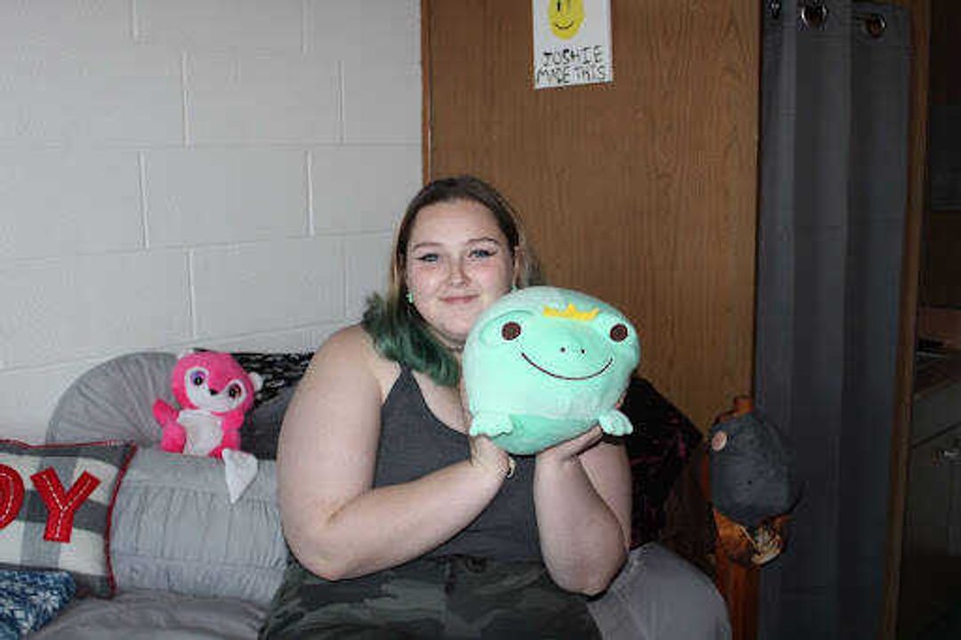 Tougle poses on her bed with a frog Squishmallow. “My favorite Squishmallow is my frog, Steven,” sophomore Jessica Tougle said. “My boyfriend got him for me while we were separated for the summer, and I had no idea I was getting him. I love frogs, and he's just so cute!”
