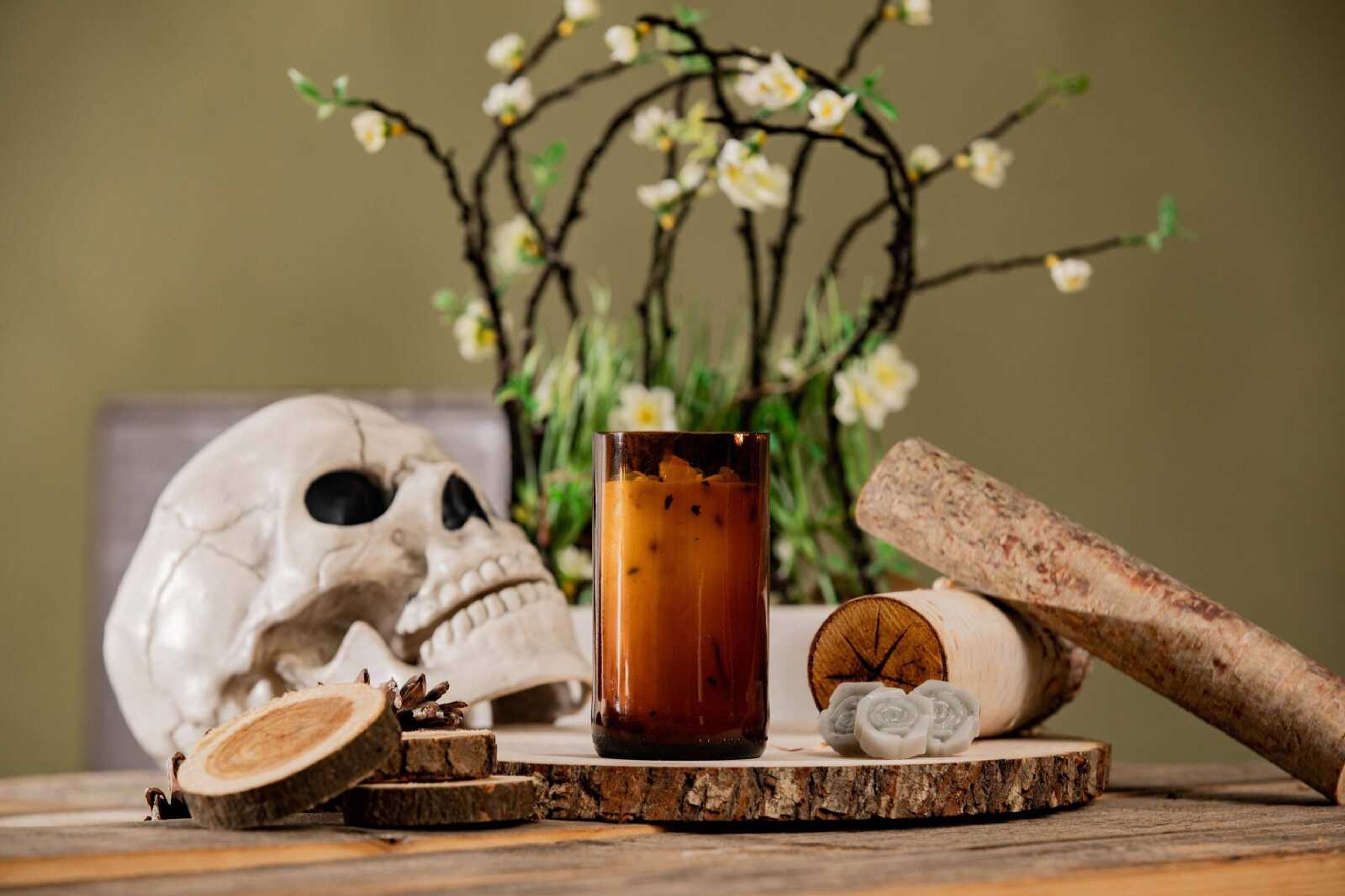 Haunted forest scented candles are displayed among pine cones and skulls. Each candle costs eight dollars and can be pre-ordered on SEMO Scents social media. 