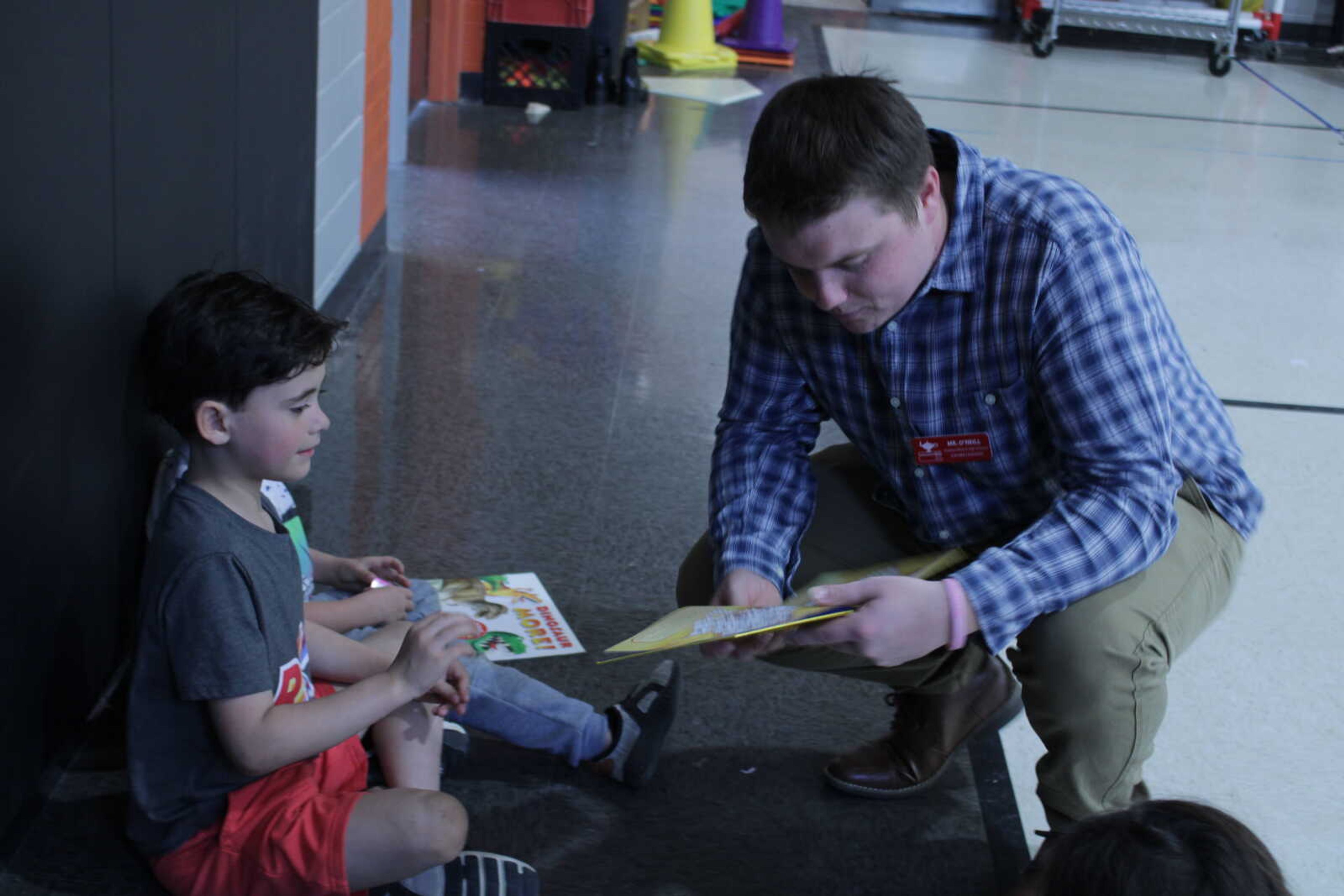 Special education major and SMSTA president Brady O’Neill reads a book to Alma Schrader Elementary School kindergarten students. O'Neill said he enjoys providing students with their very own books to read at home.