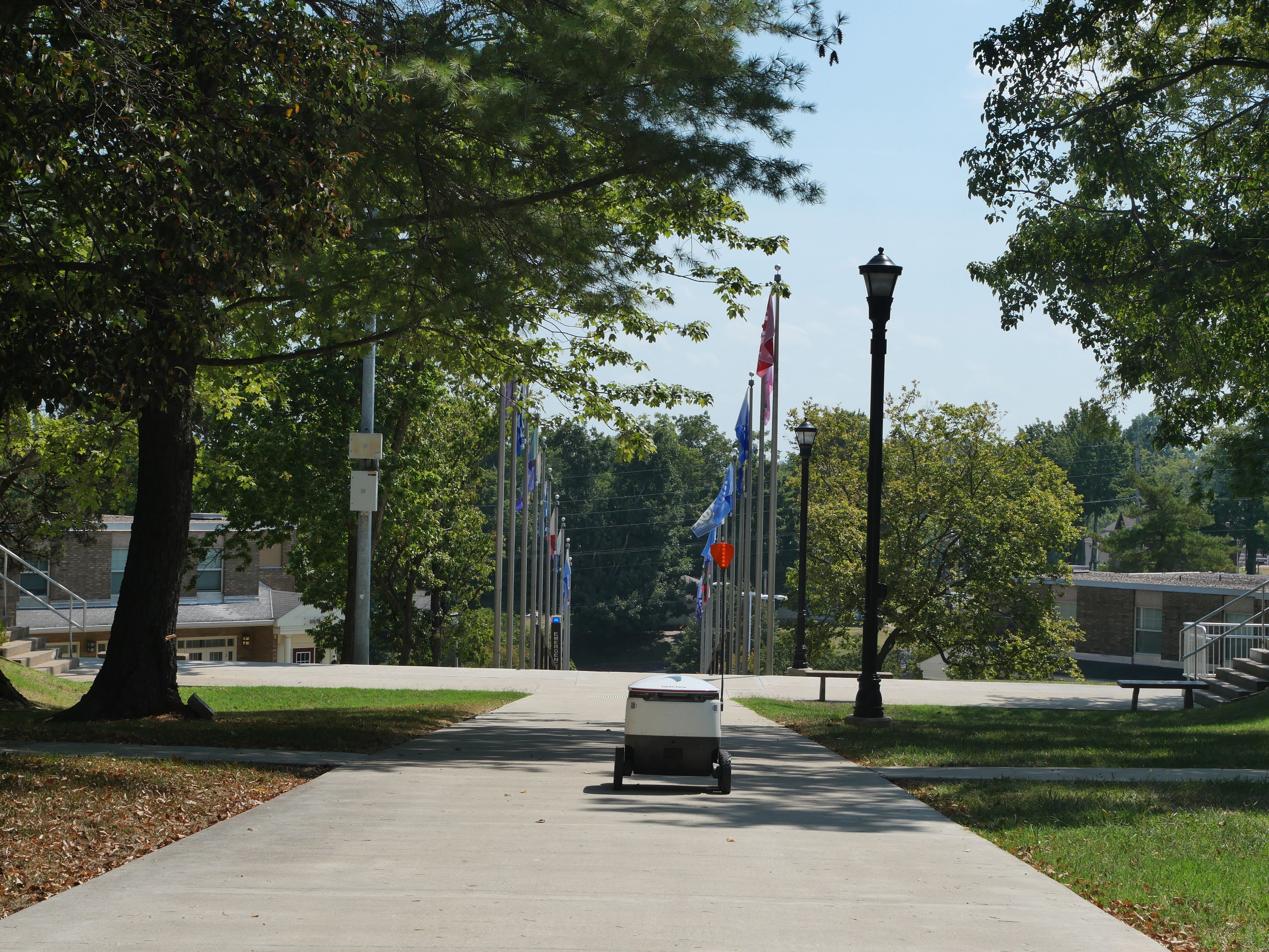 Starship Delivery Robot travels down Greek Hill to reach its final destination of Towers Residence Hall.