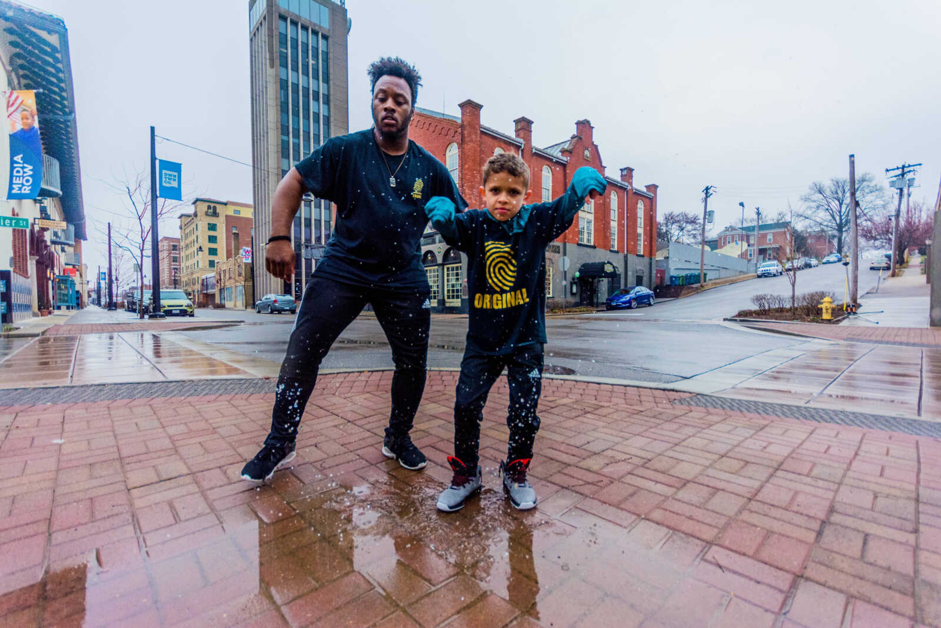 Micheal "Crank" Curry, left, and his student Christopher Guada, right, dance in the middle of Broadway Street in downtown Cape Girardeau.