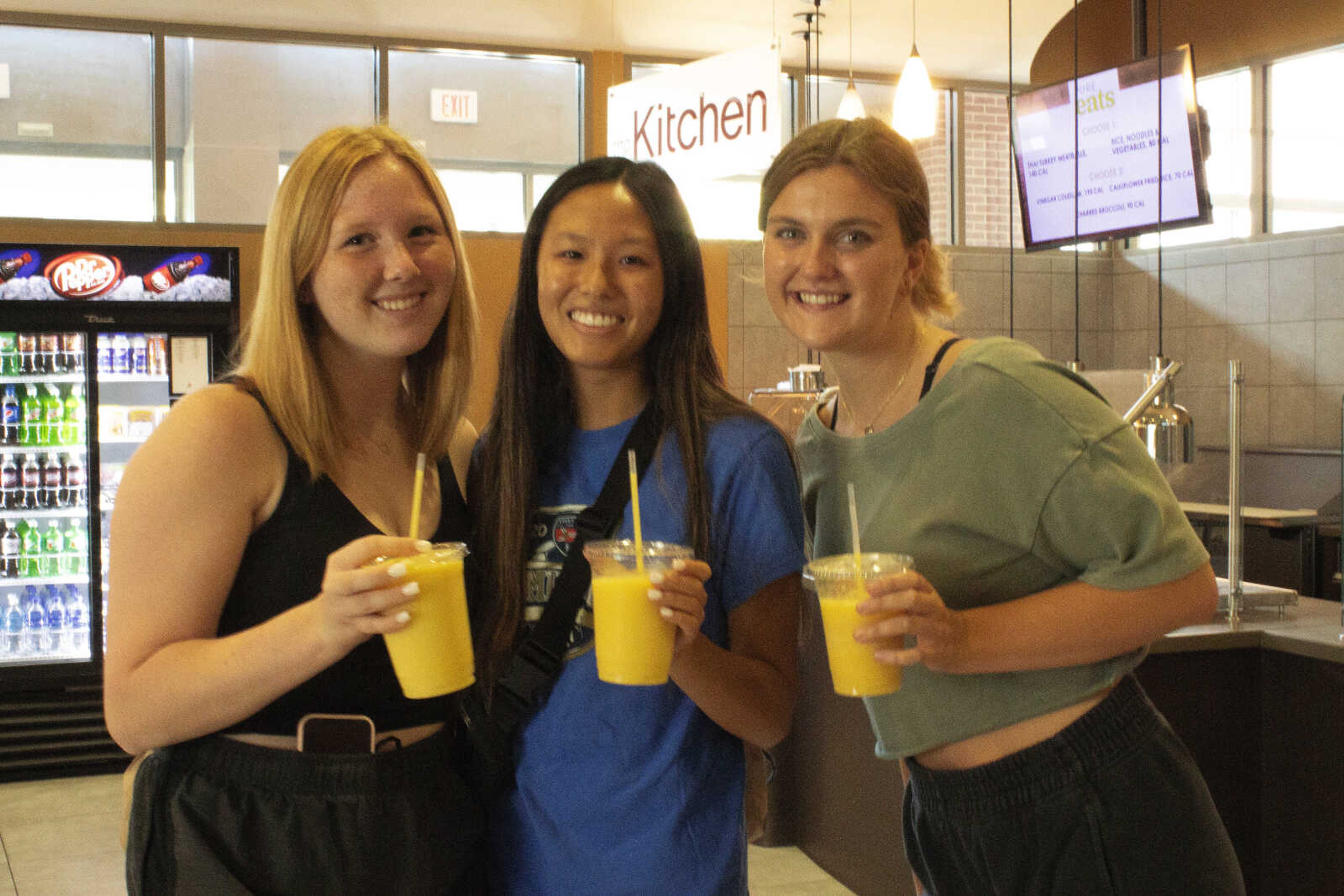 Amber Lynn Greenwood (middle) stands with her friends holding their smoothies from Smoothie Lab. 