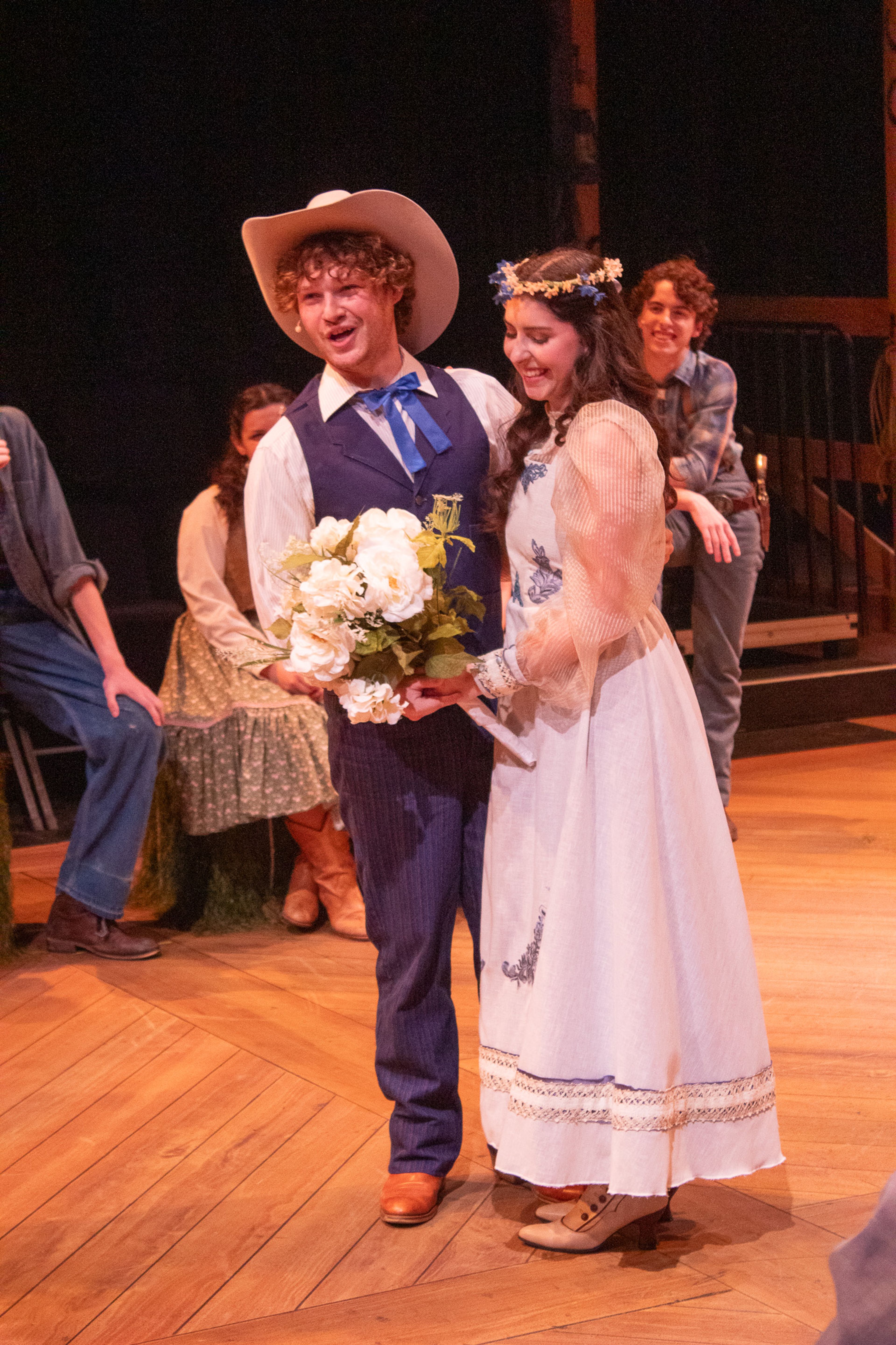 Curly played by Garrett Langley and marries Laurey played by Elise Bowels. Curly tells the others how he'll have to go from a cowboy to a farmer.