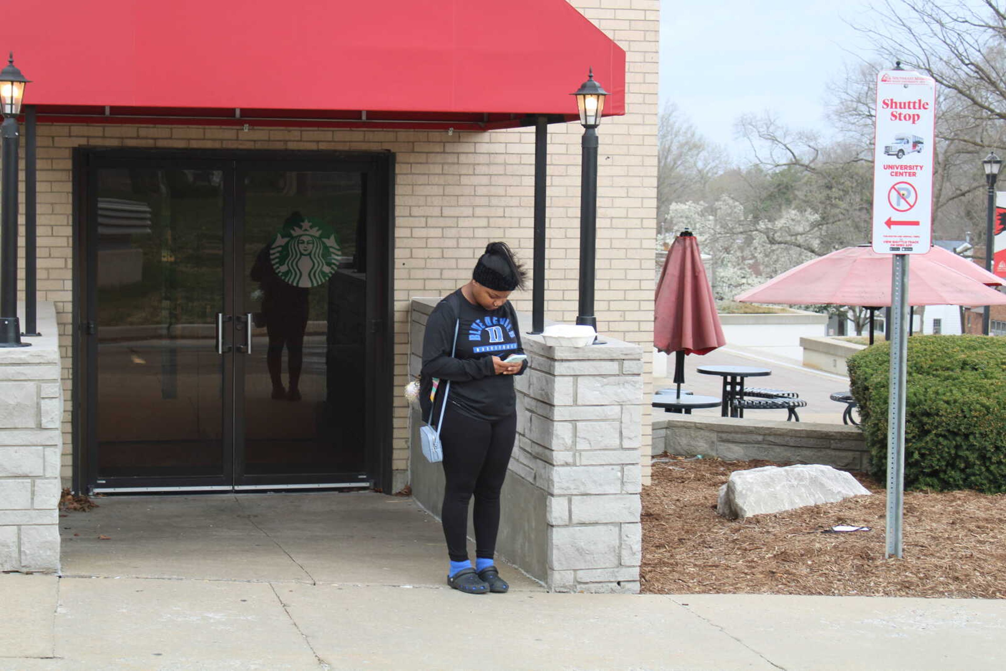 Geinia Wynn waits outside Starbucks for the shuttle bus. The tracking system has not worked for the majority of the spring semester.
