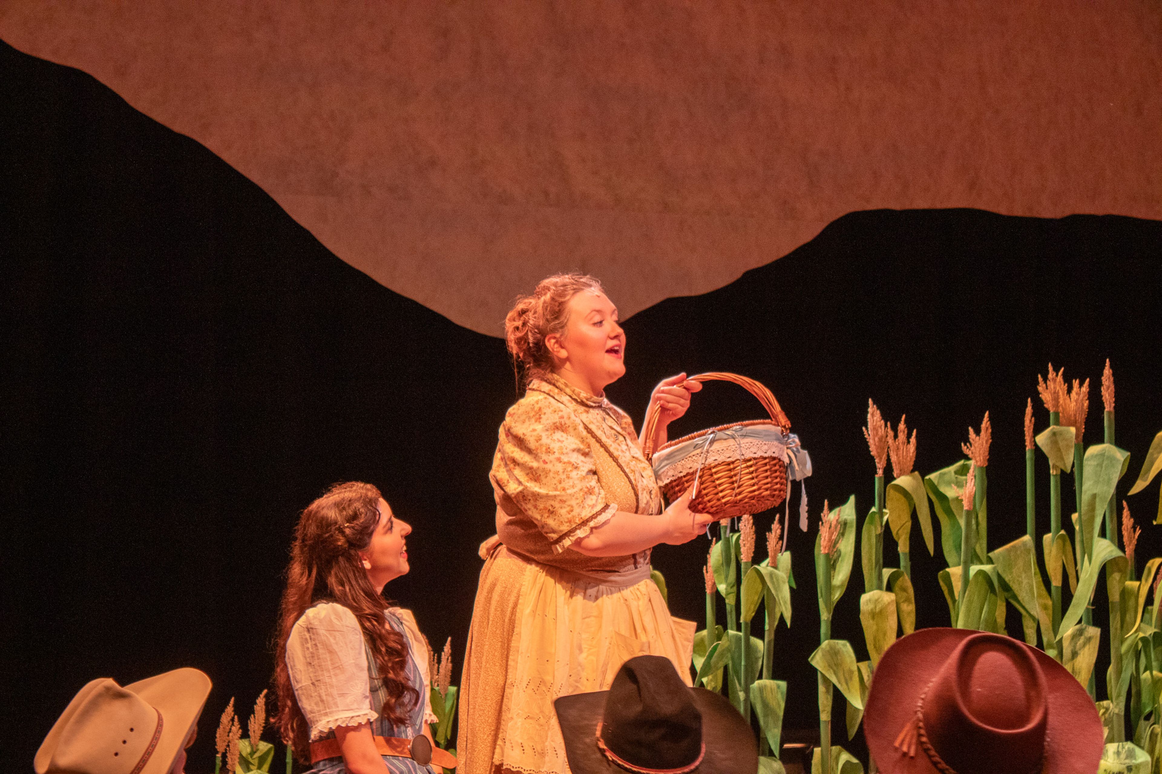 Aunt Eller played by Grace Fisher starts auctioning off Laurey's lunch basket to the men.