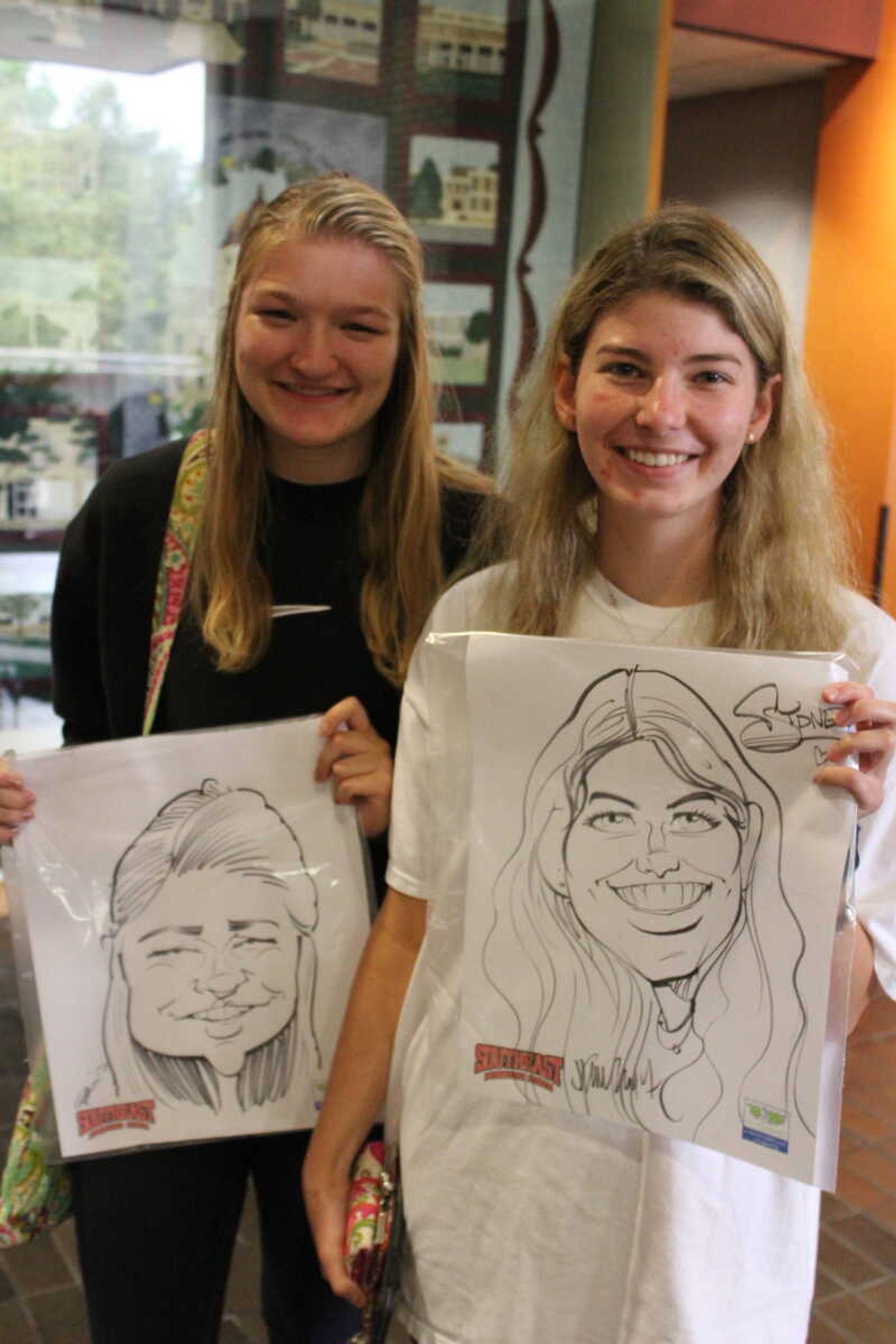 Sydney Dittlinger and Kaylee Backfisch pose with their Caricature in the UC on Oct. 11.