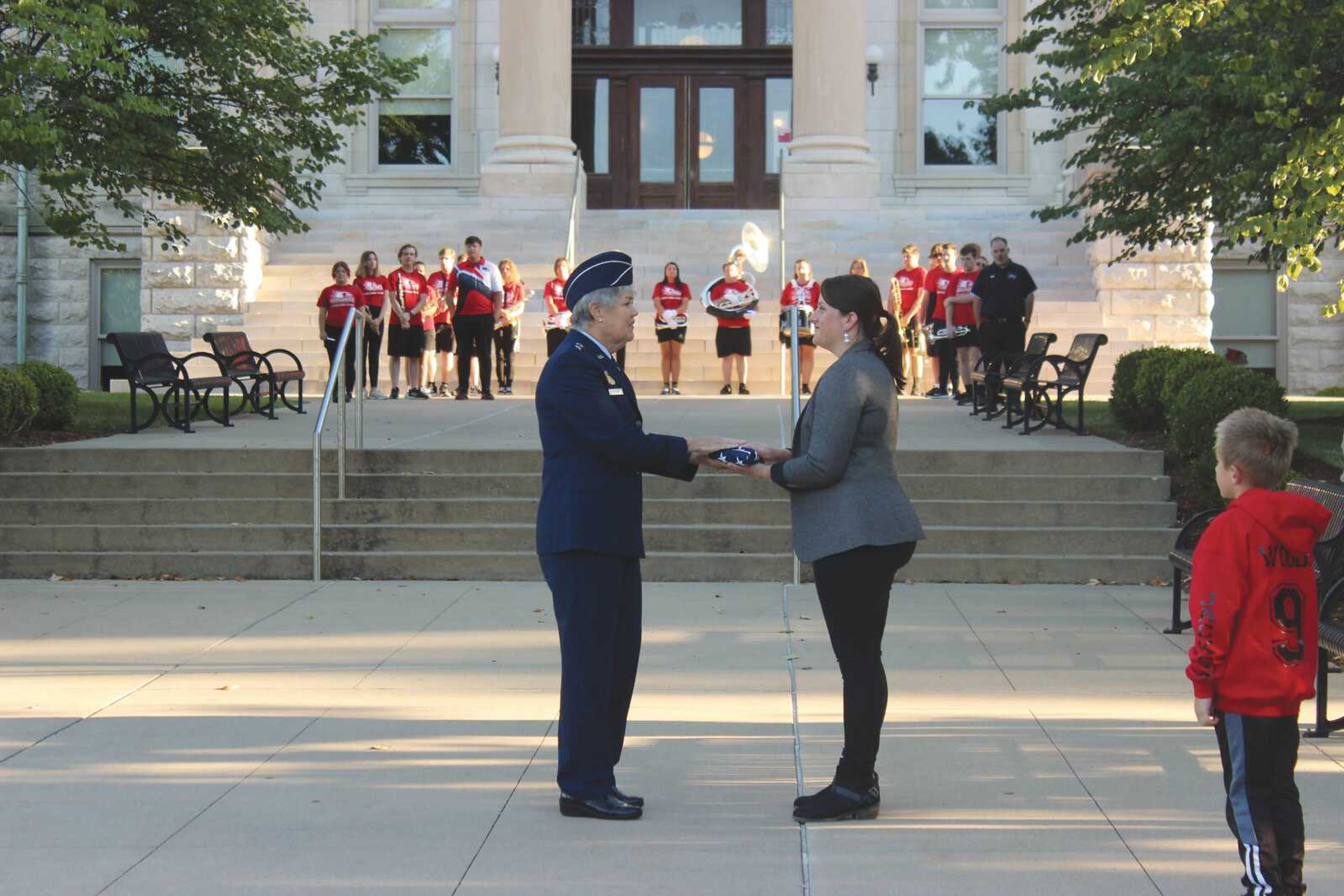 Retired National Guard-Major General Cassie. A Strom recieved an american flag from the SEMO Liason to Student Veterans and Military Amanda Woods. The flags that were handed out were flown over cities that were attacked in America on Sept. 11, 2001.  Woods’ son stands nearby to watch his mother recieve the honorary flag.