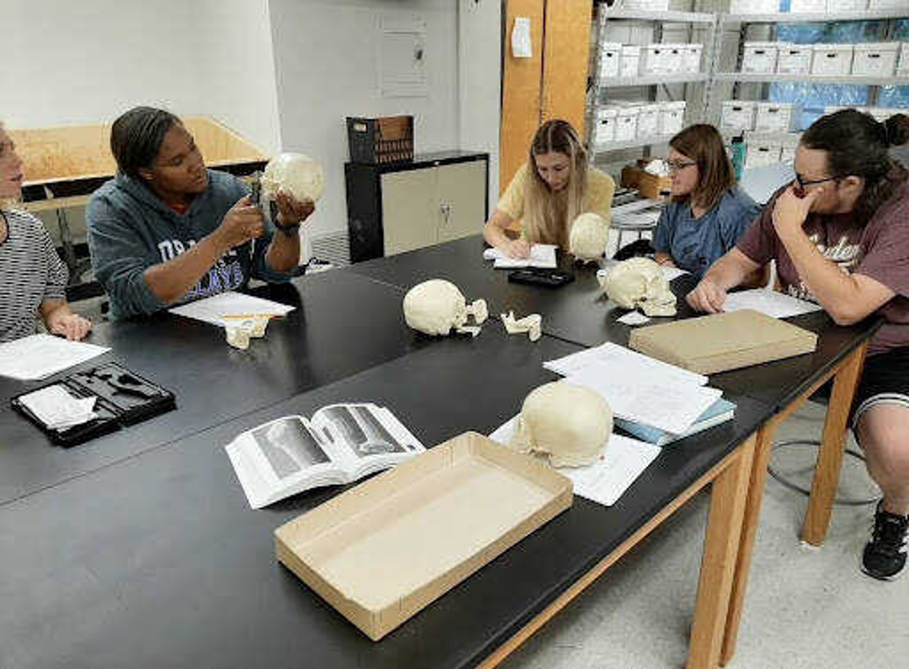 Anthropology students learn about human osteology with fake bones. Understanding bone placement and structure is a crucial part of forensic anthropology studies according to anthropology professor Jennifer Bengston. 