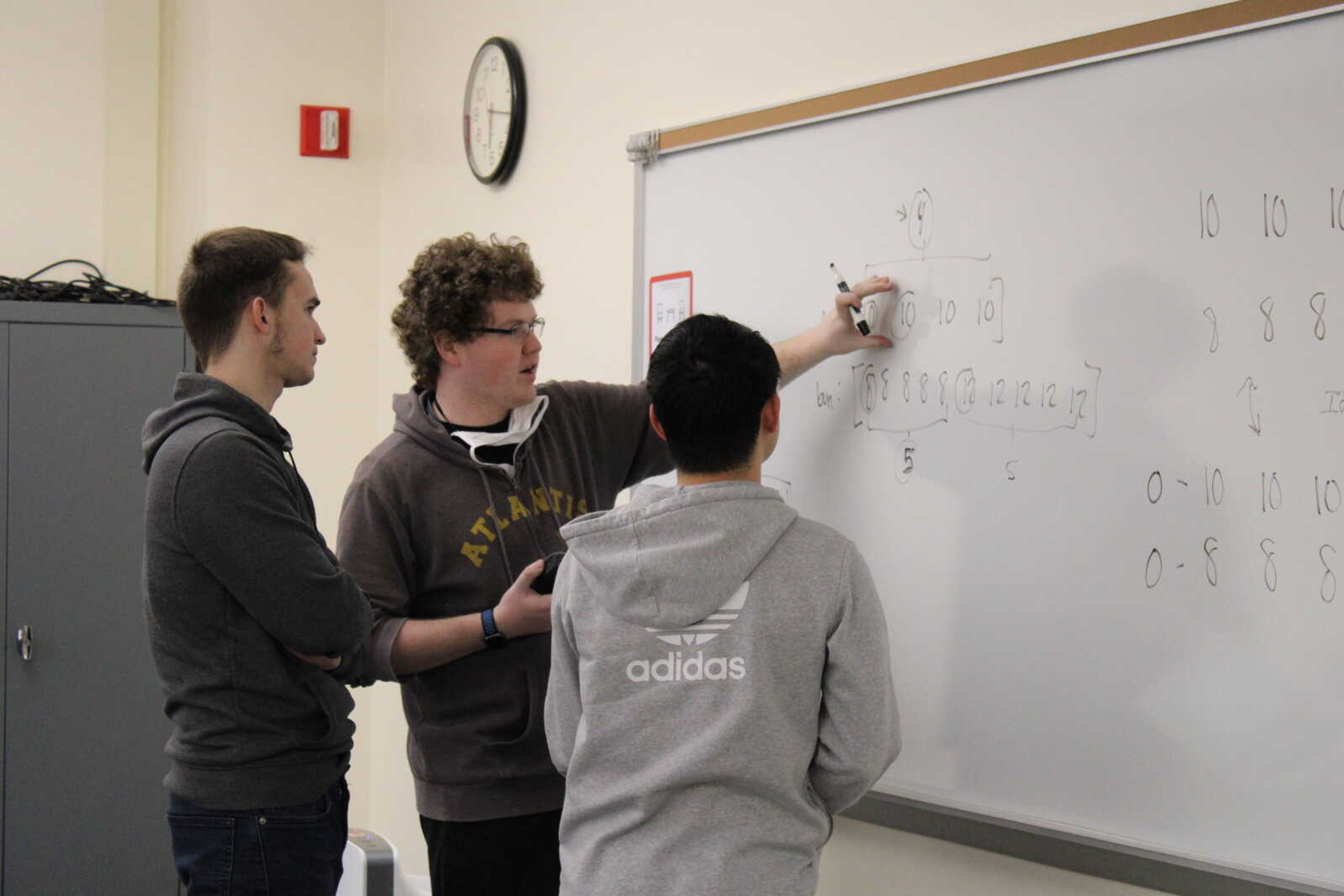 From L-R: ICPC president Alex Seredovych, vice president Blake Bleem and club member Xiao Pu work together to solve a practice programming problem. Practice problems mirror those in competitions as well as job interviews.