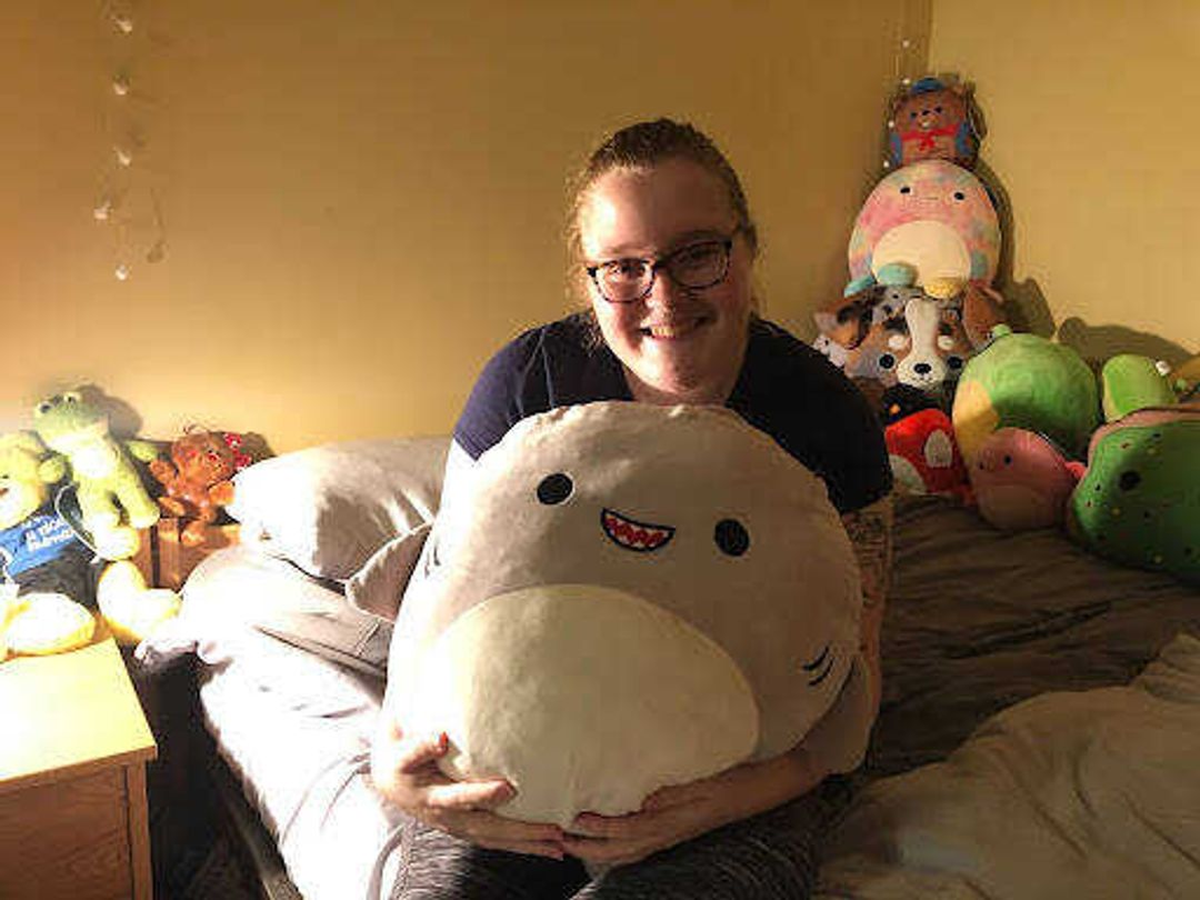 Bilek poses on her bed with a large shark Squishmallow. “Gordon is my favorite because he was the first squish that got me into collecting! My boyfriend was the one to get him for me and his smile makes him stand out.” junior Carly Bilek said. 