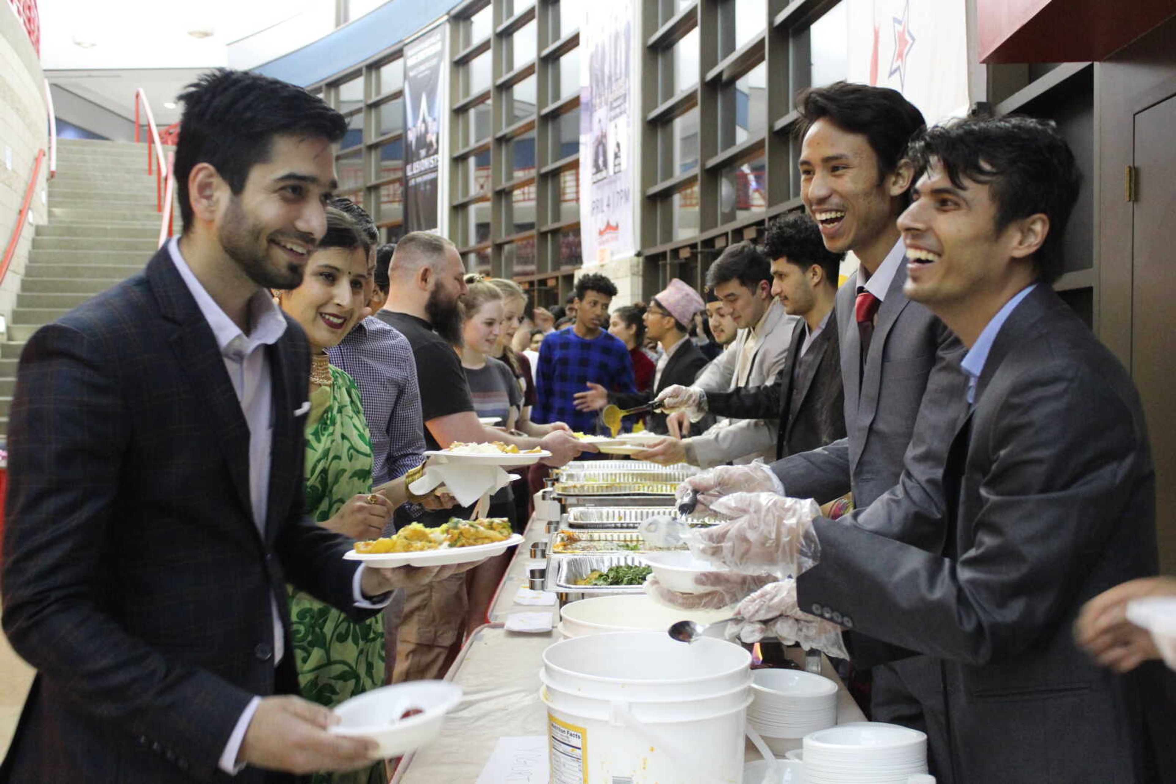 NSA members serving Nepali dishes to attendees. 