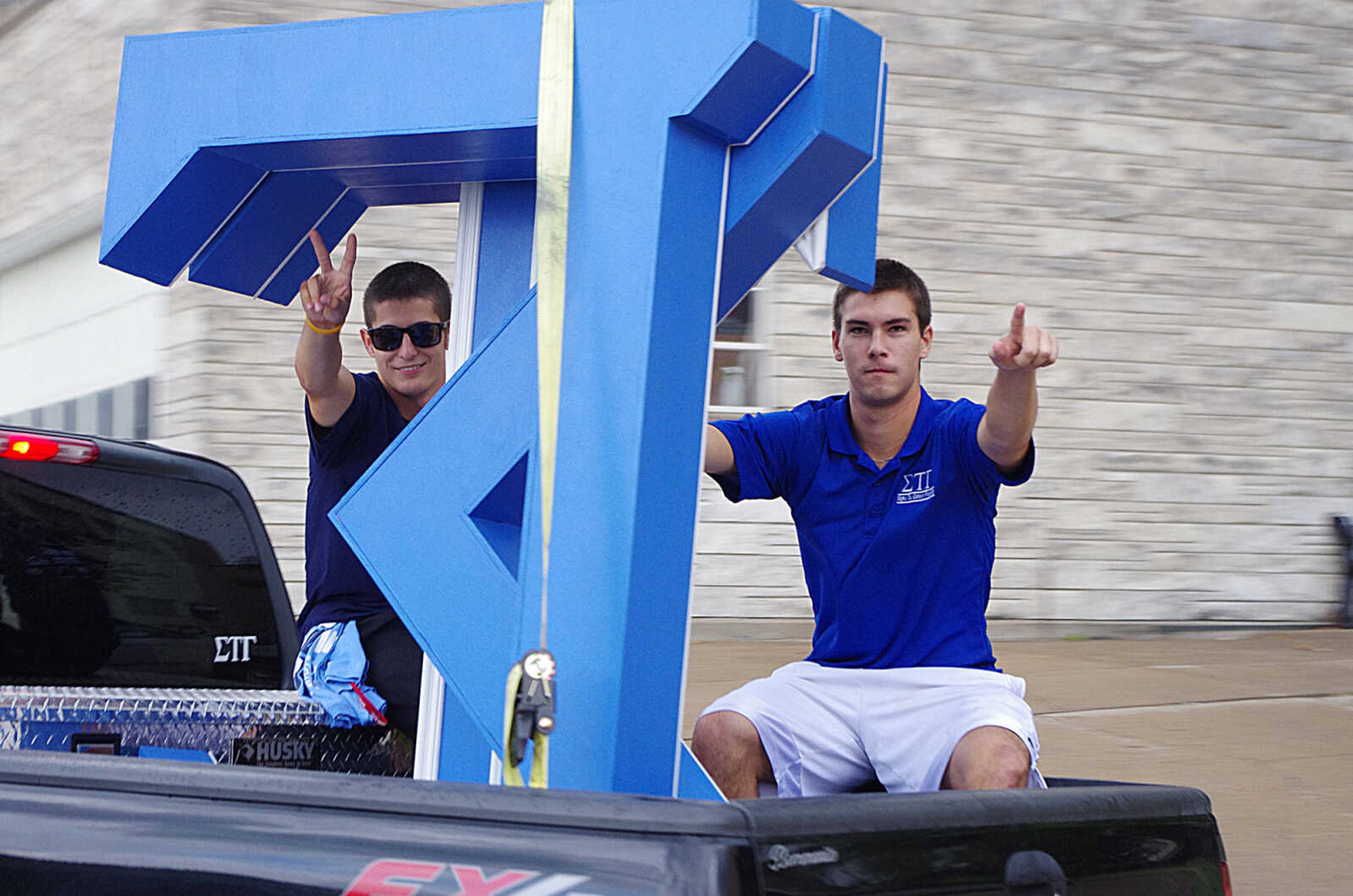 Two members from Sigma Tau wait at Parker Field until the new recruits come from the UC for their annual runs after Bid Day. The fraternity members had their music playing and their letters in the bed of the truck. Photo by Nathan Hamilton