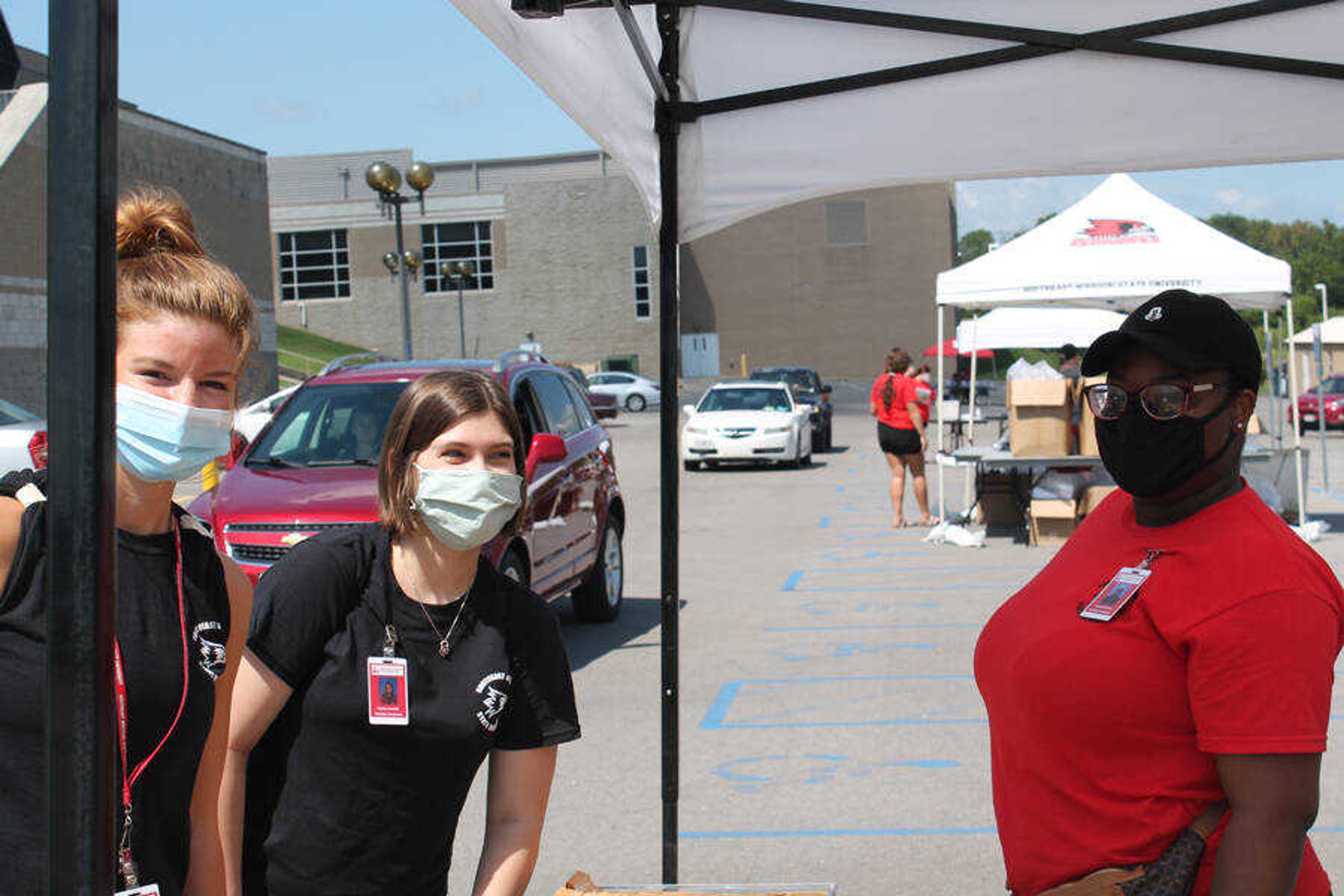 Resident Assistants Ashley Moellenhoff, Hayley Huntly and Darian Forleet distribute keys on the first day of Residence Life's drive-thru resident check-in, Saturday, Aug. 15. Returning students drove from tent to tent at the Show Me Center receiving information and a health screening before receiving their keys.
