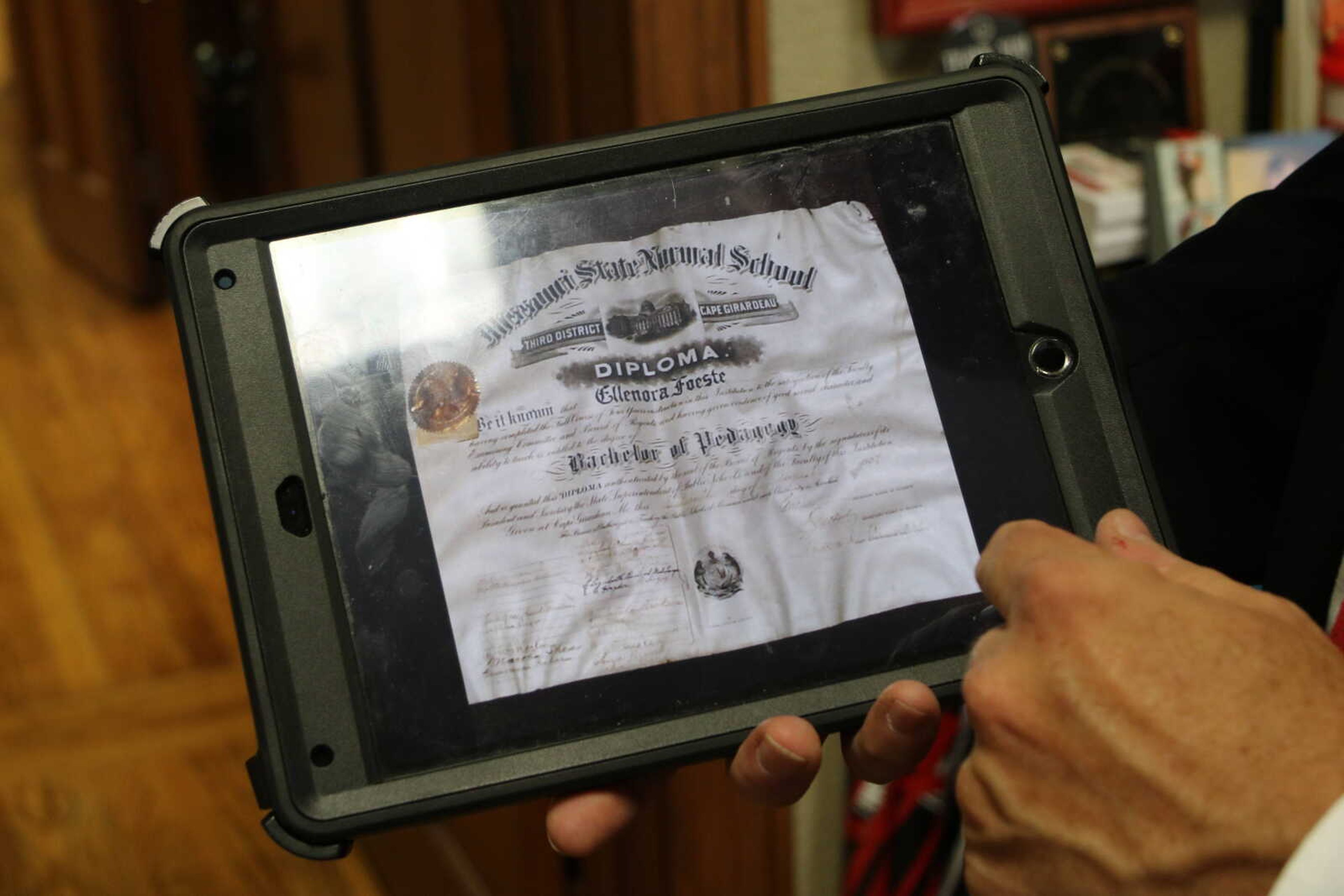 Jay Wolz shows a photo of a diploma he found and brought for $15 at an aunqiue store. Wolz was able to track down the alum the diploma belong to and return it.