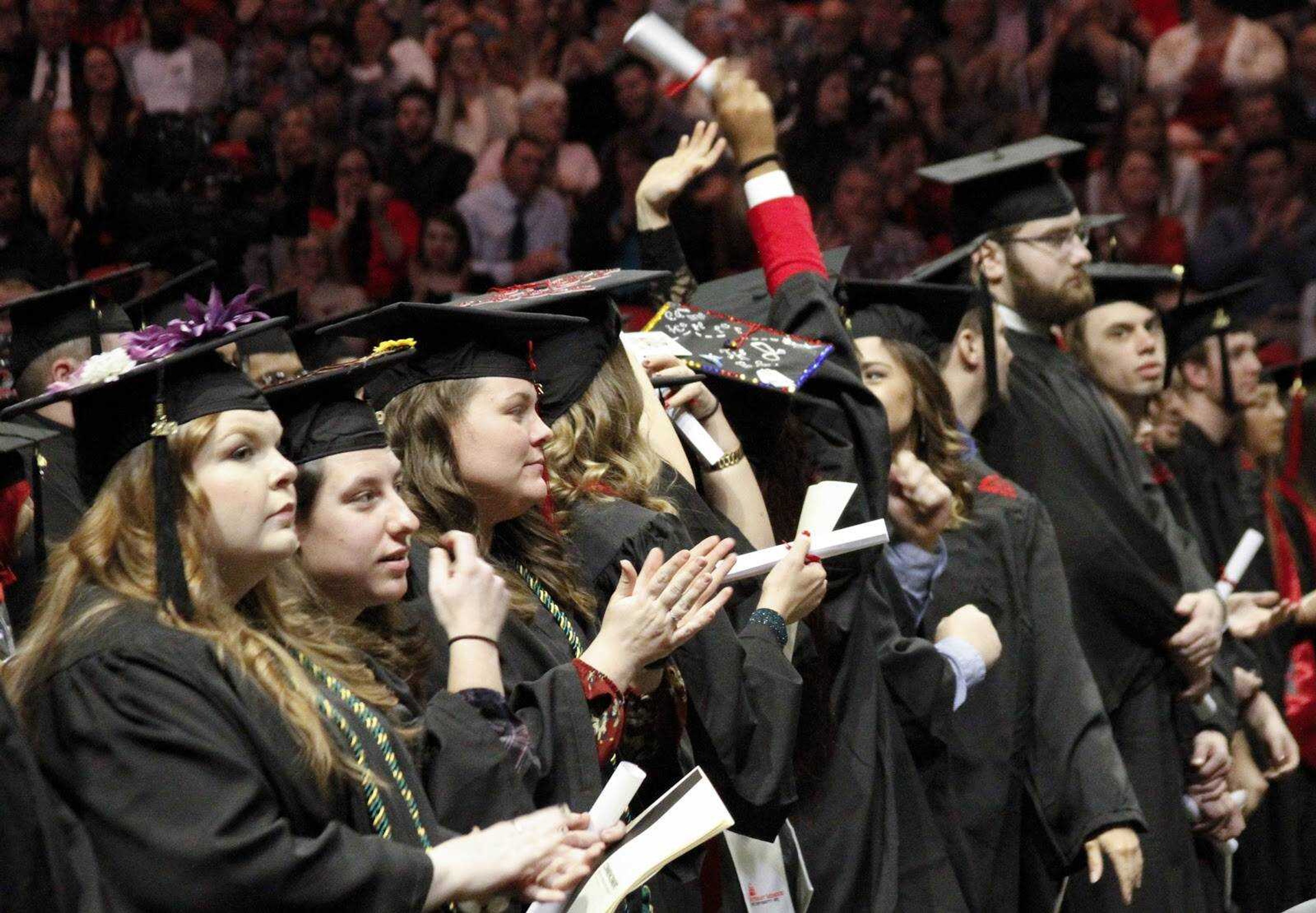 Graduates stand holding their diplomas during the Fall Commencement ceremony Dec. 14 at the Show Me Center in Cape Girardeau, Missouri.