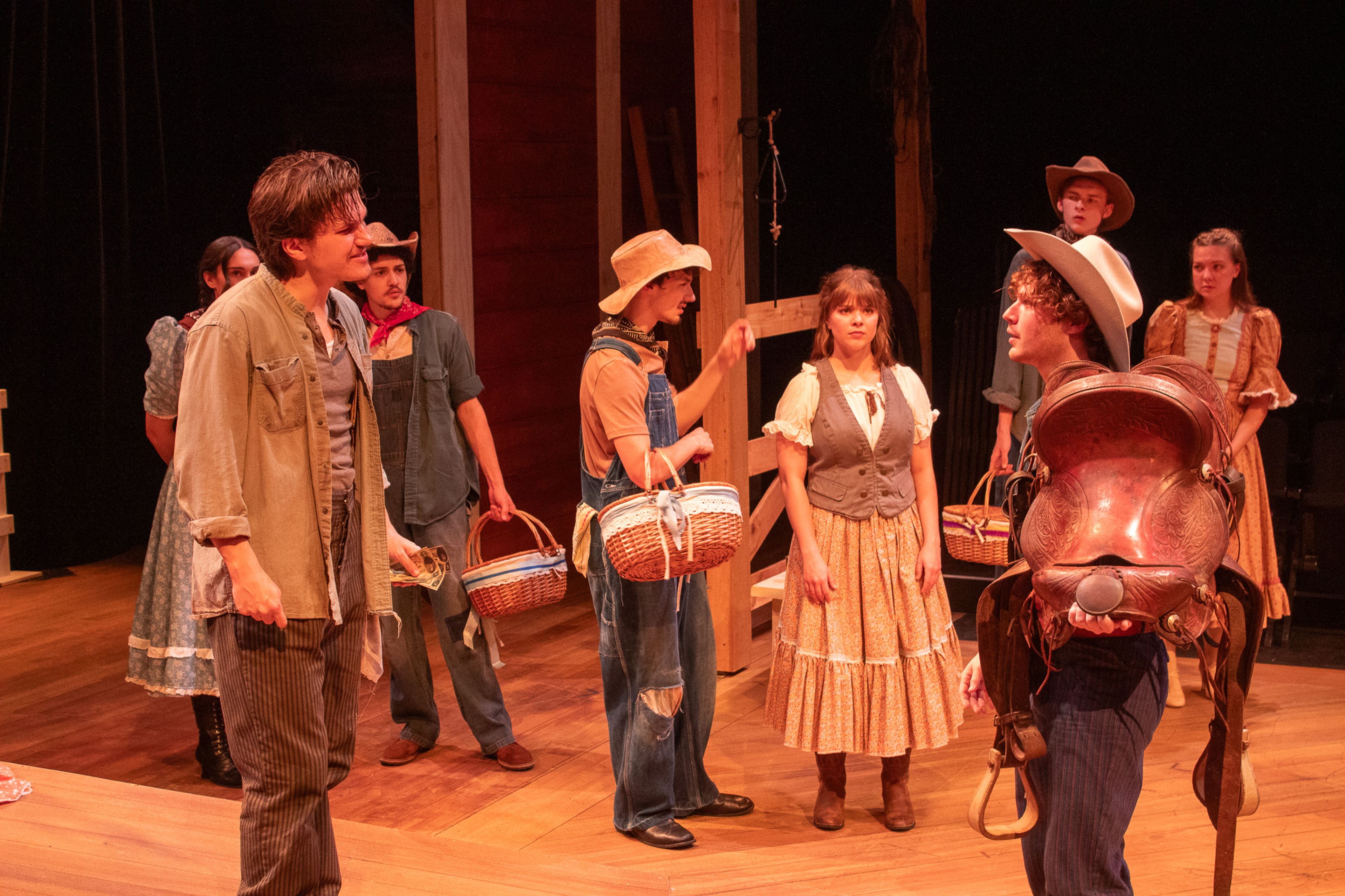 Curly, played by Garrett Langley, can stand to see Jud bid on Laurey's basket and sell his saddle to outbid Judd, played by Luke Boucvalt.