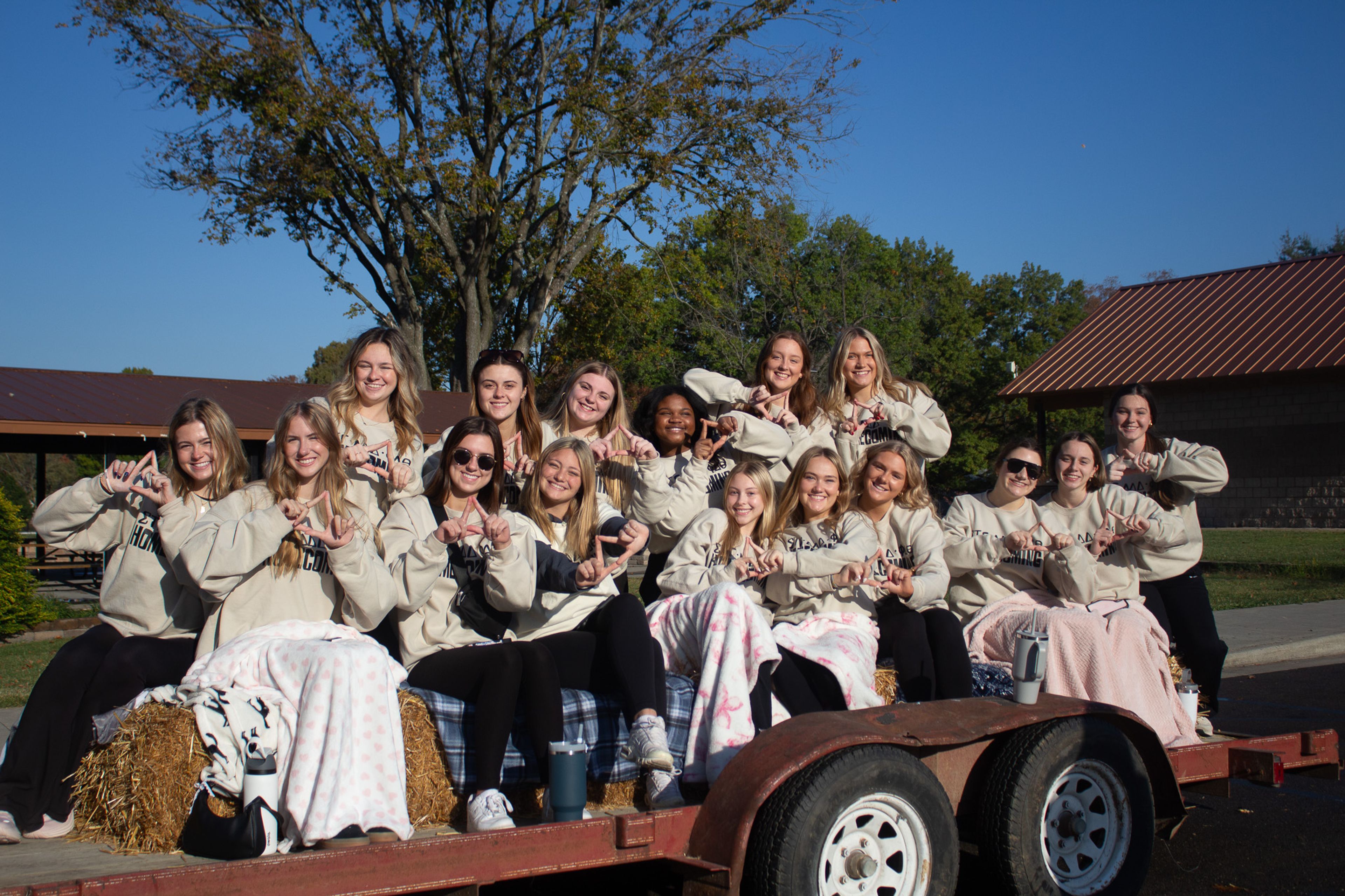  New members of Delta Delta Delta pose to show off their letters before chanting in the Homecoming parade.