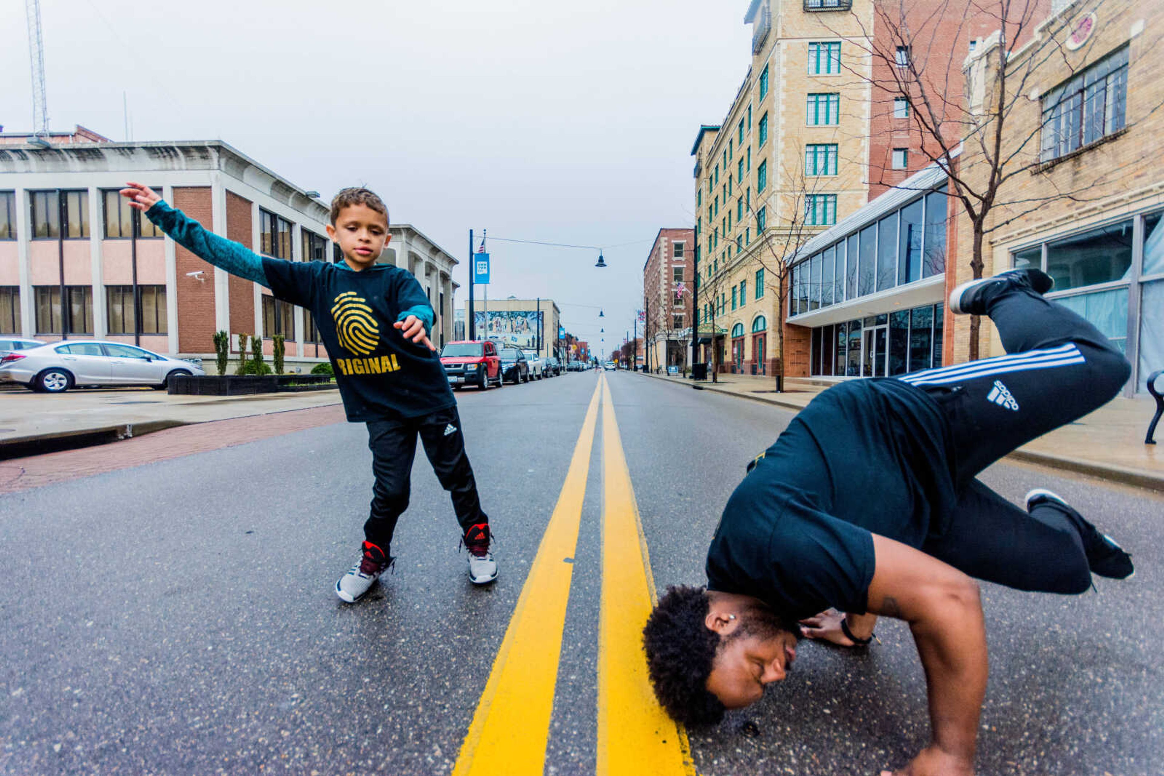 Christopher Guada, left and his teacher Micheal "Crank" Curry, right, dance in the middle of Broadway Street in downtown Cape Girardeau.