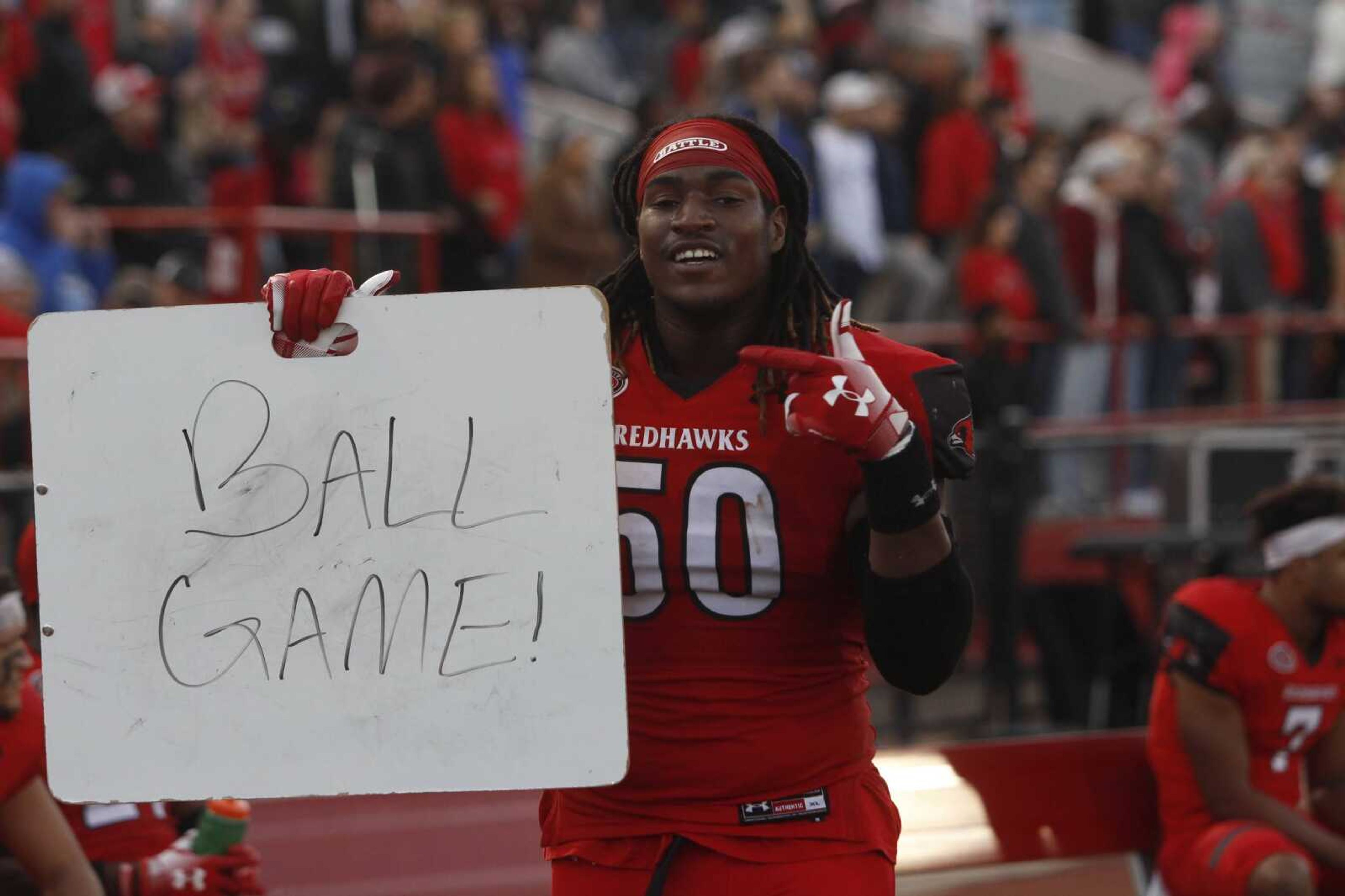Junior defensive lineman Clarence Thornton points at a sign reading "Ball Game!" after the Redhawks defeated the Seawolves 28-14 in the first round of the FCS playoffs.