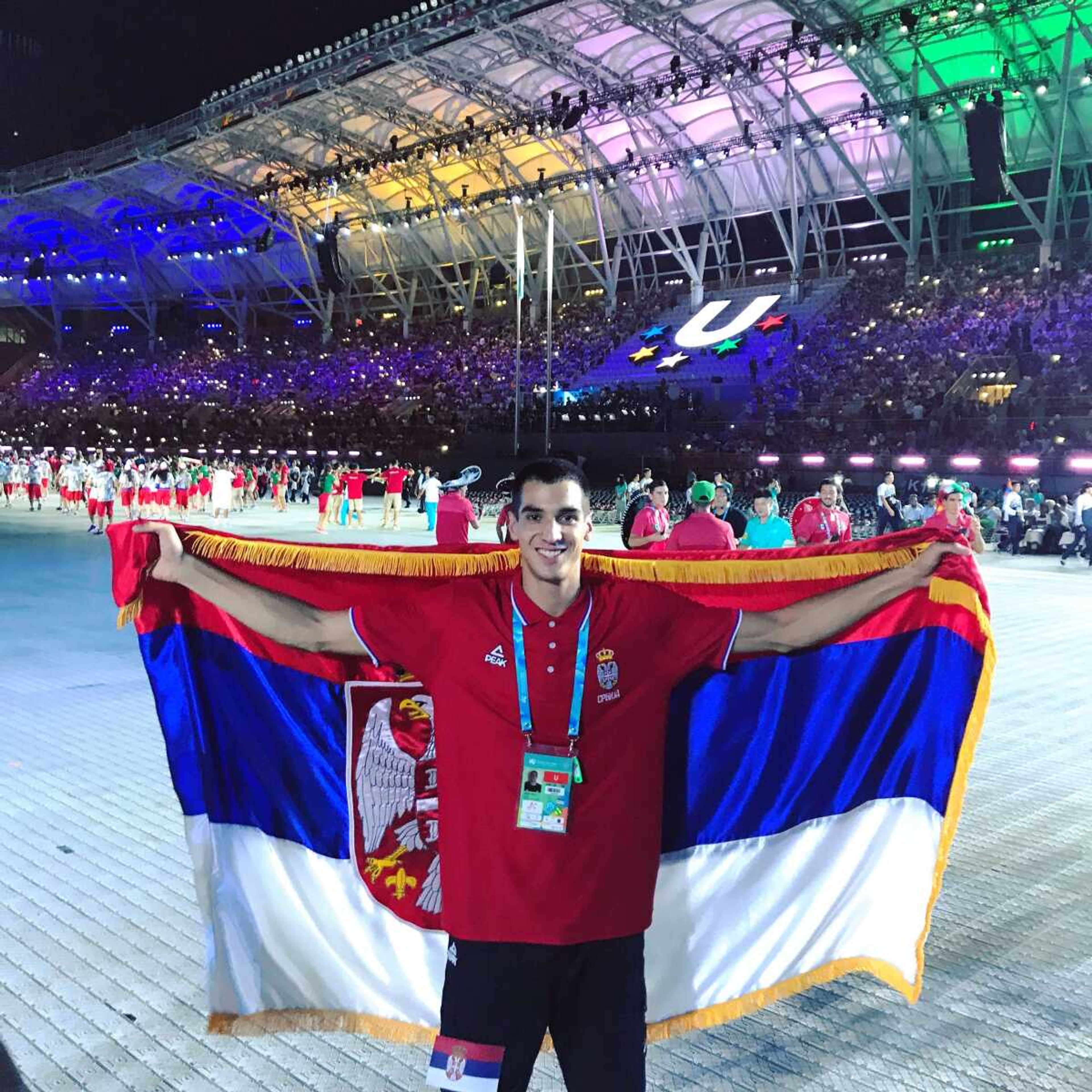 Milos Vranes poses with the Serbian flag at the opening event. 