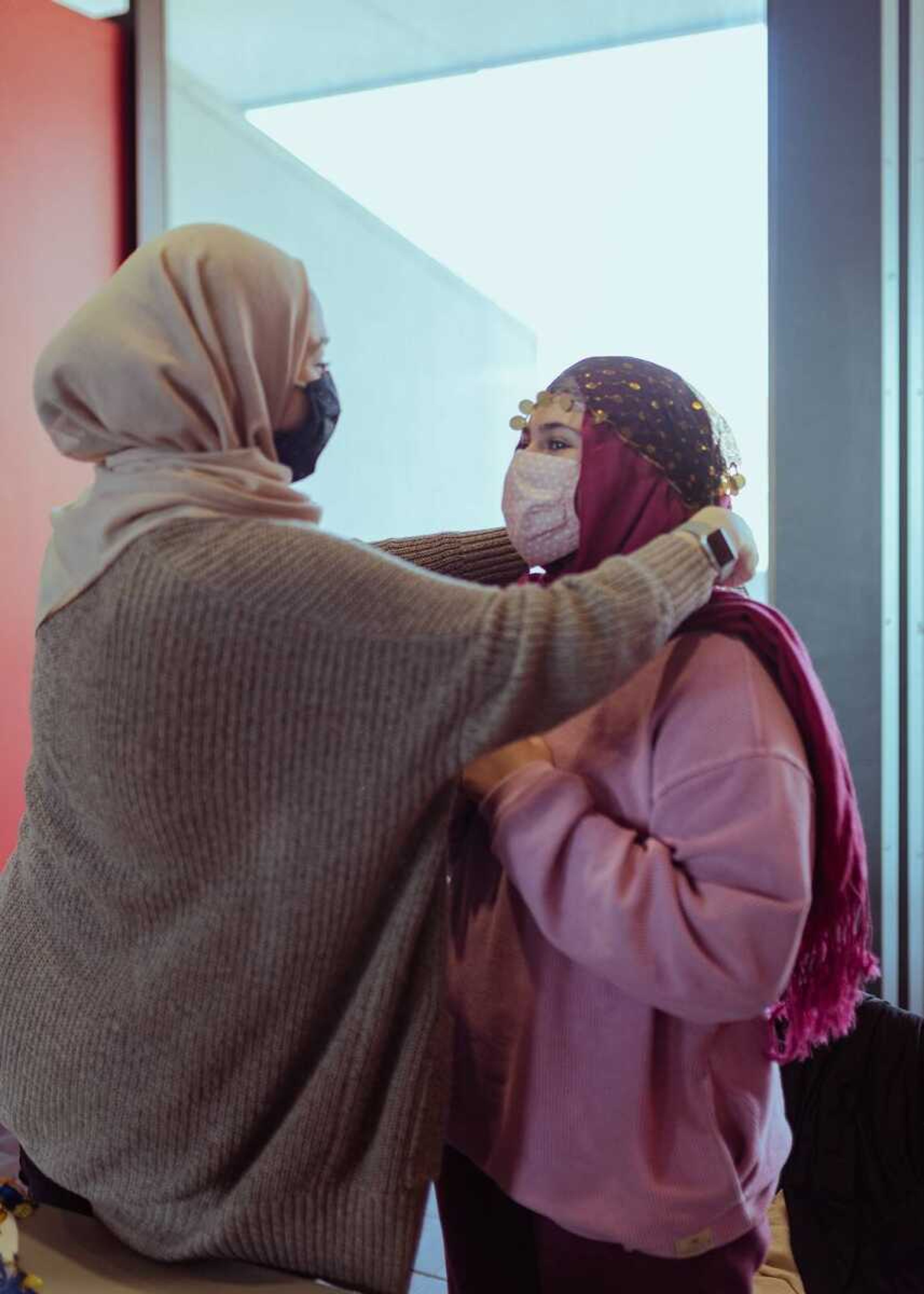 Shadan Roumany demonstrates putting a decorative headscarf onto Jowairia Khalid at the World Hijab Day put on by the Muslim Students Association.