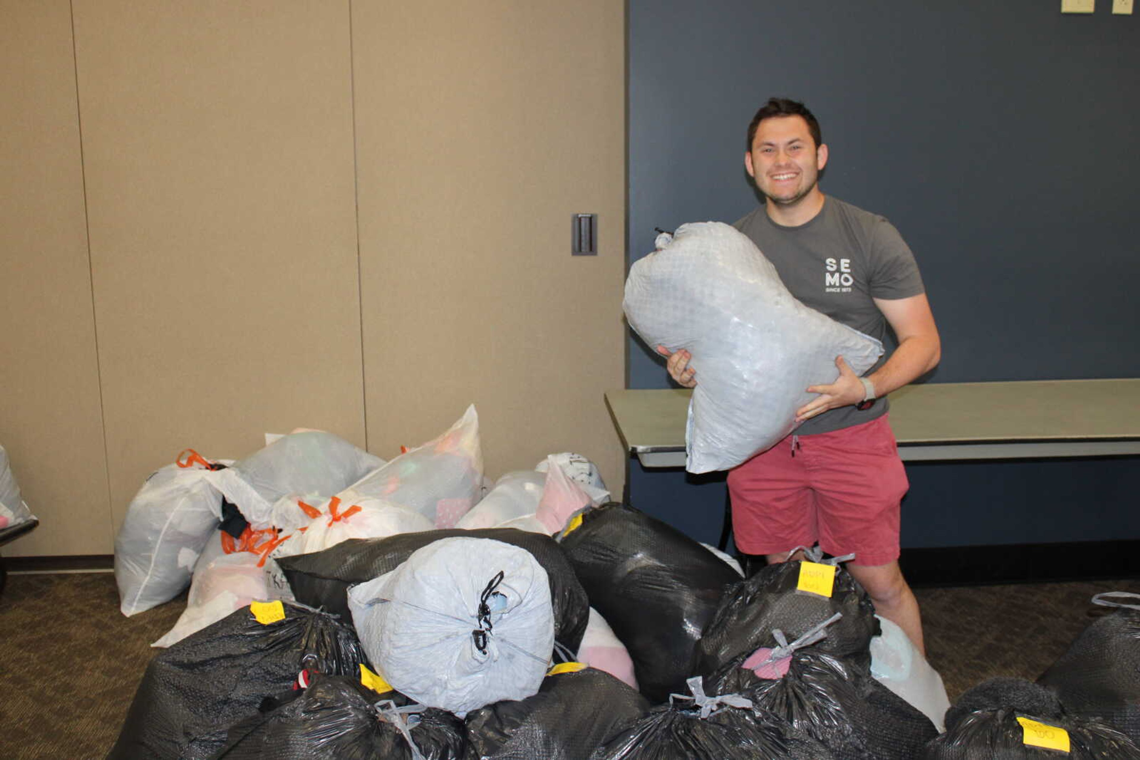 Sophomore social studies education major Frankie Kulavic is the philanthropy chair for this year's Greek Week. Kulavic stands with bags of clothes collected for the clothing drive.