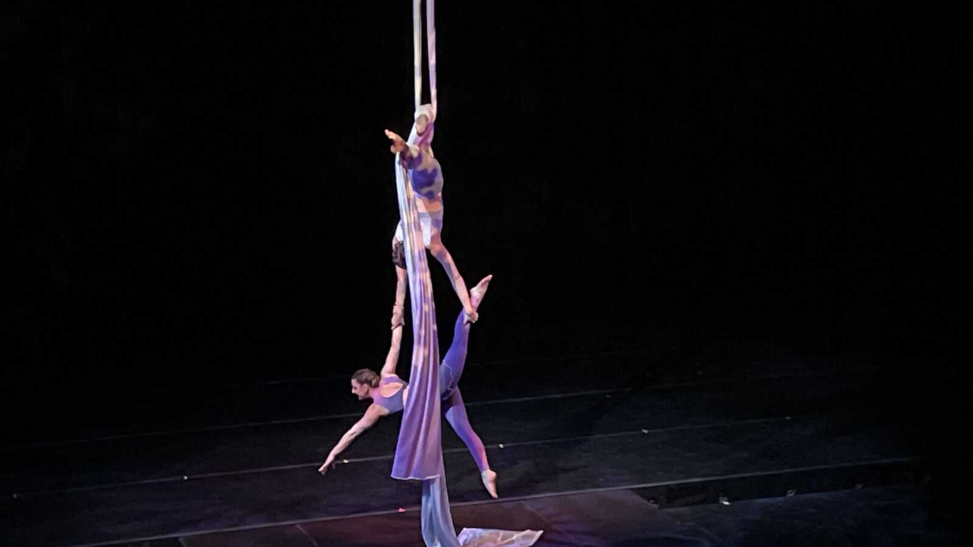 Dancers perform aerial acrobatics on silks during the Spring into Dance 2022 show.