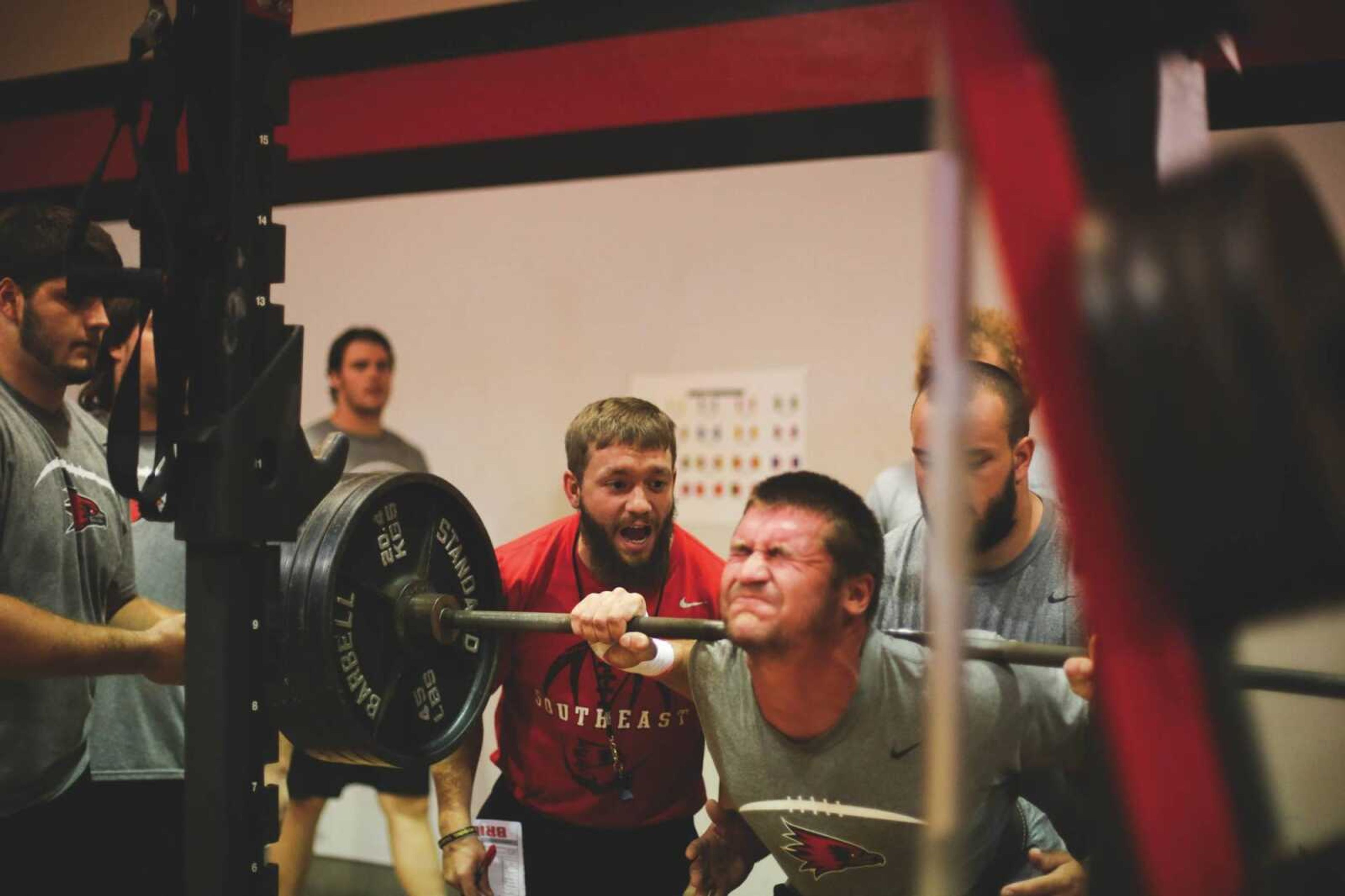 Strenth and conditioning coach Justin Guy motivates a Southeast Missouri State football player to complete his squat repetition at the Success Center on Sunday.