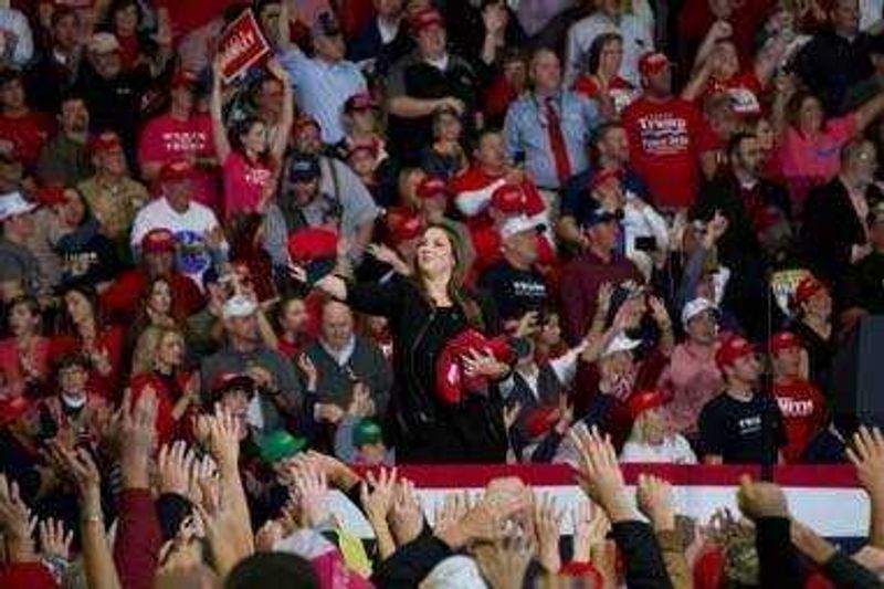 MAGA hats and tshirts into the crowd as they await the arrival of President Trump at his last rally of the Midterm Elections in Cape Girardeau Nov. 5.