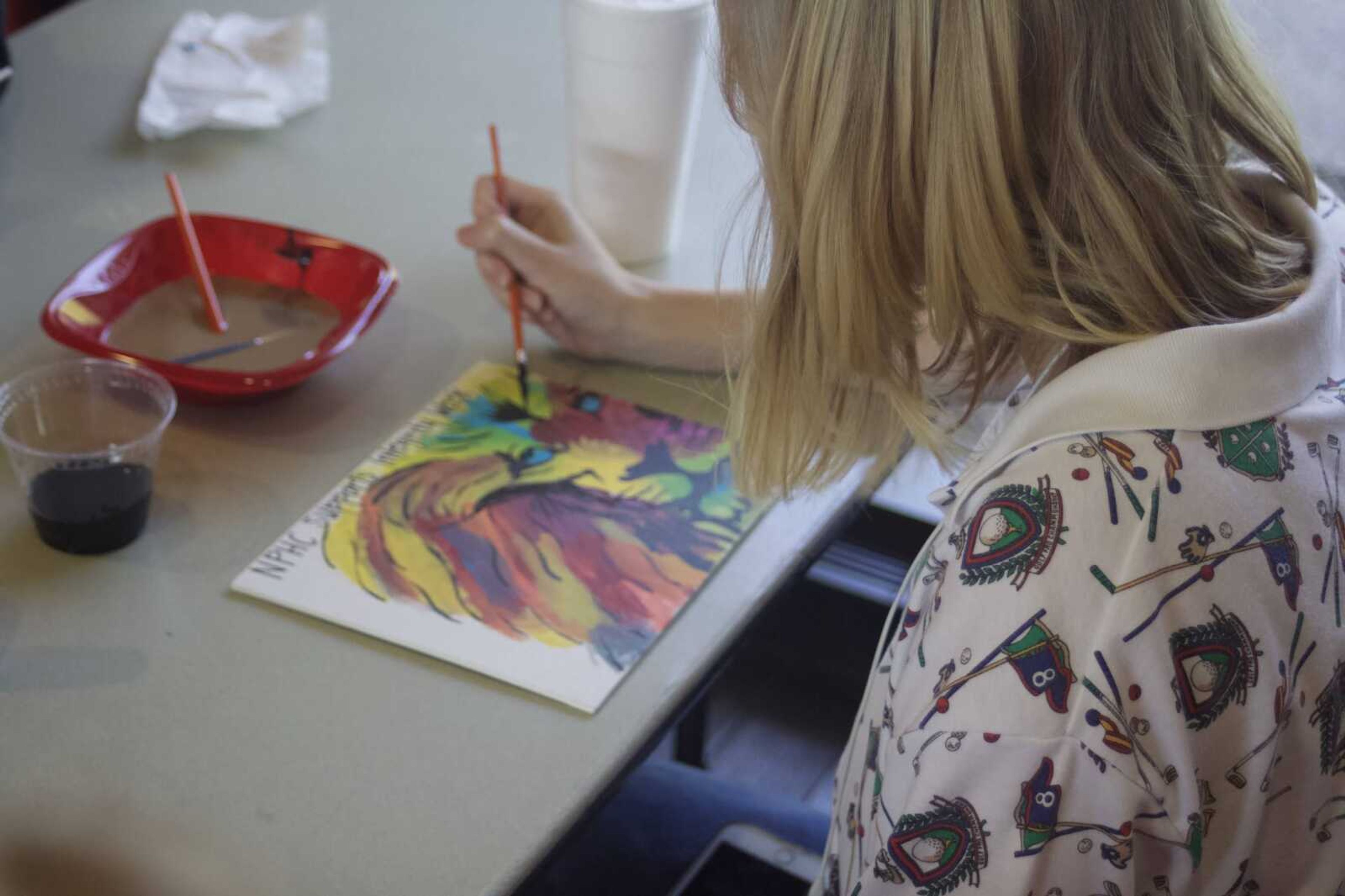 Rachel Kroeger, freshman at Southeast painting a picture of a lion to represent integrity
