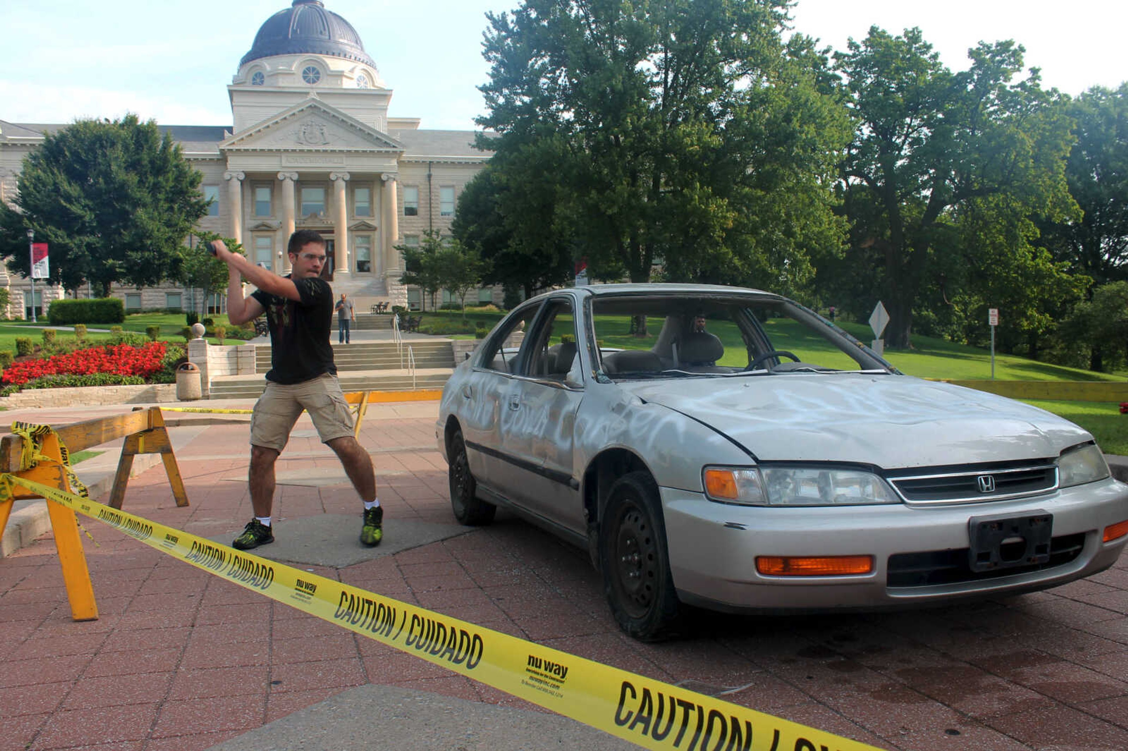 Xavier Bertmann takes a swing at the car used in the "TKE Out Cancer" event hosted on Aug. 24.