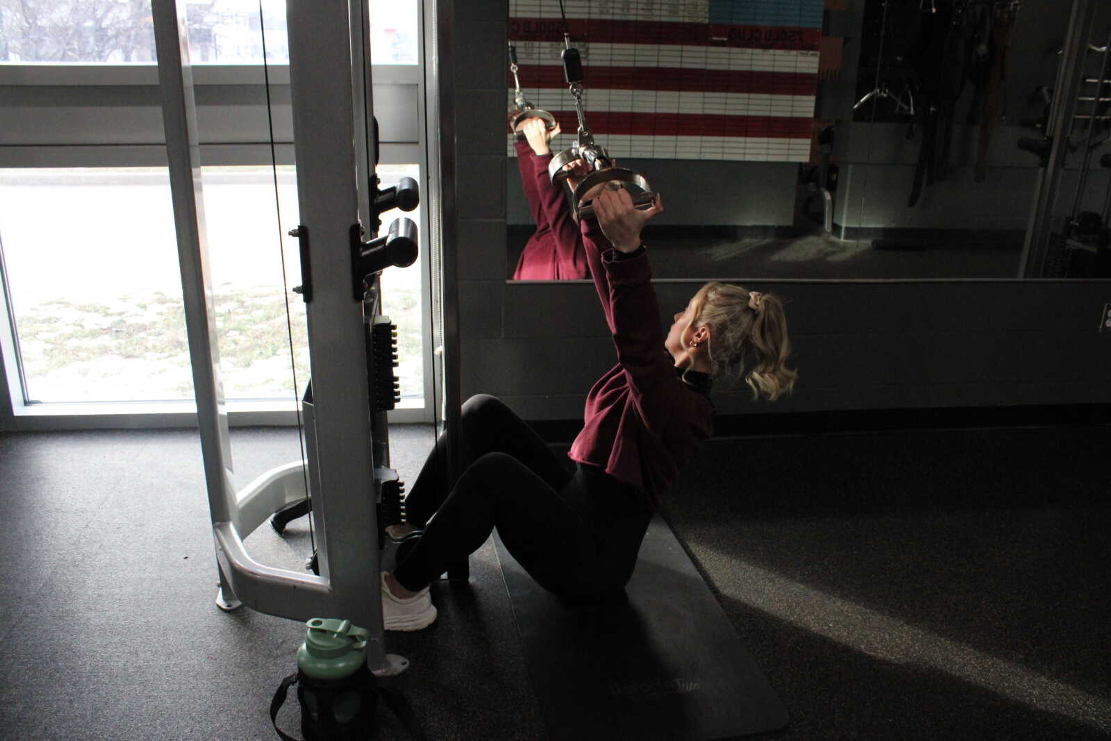 Senior dietetics major Macie Brinkopf demonstrates a latteral pull-down. Brinkopf attends Healthpoint Fitness gym in Cape Girardeau.
