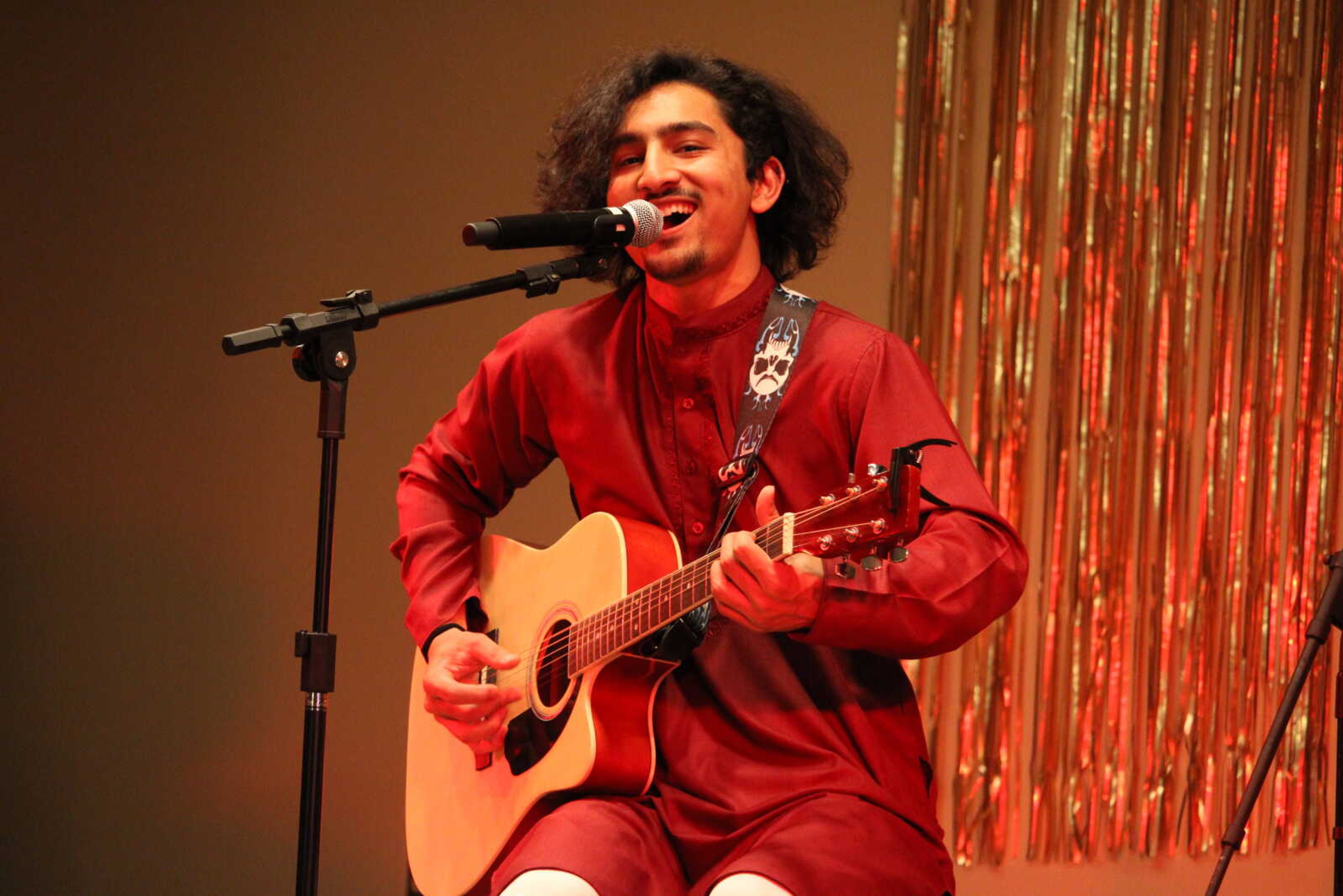 Nepalese student Suraj Khatri entertains guests with a guitar solo. Music and dancing were all a part of Nepali Night at the UC ballroom.
