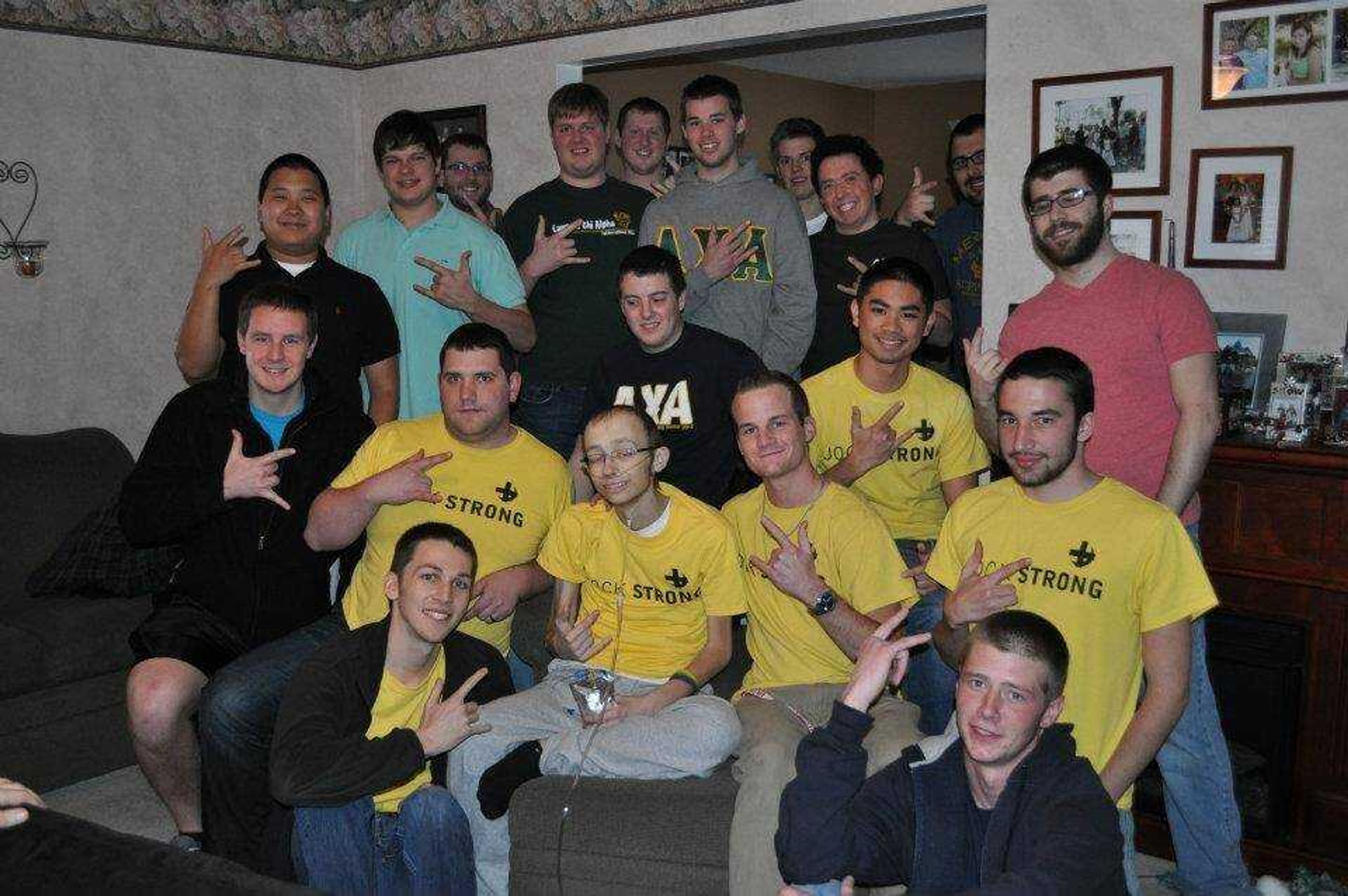Scott Wood (center) with his fraternity in his O'Fallon home in February. - Submitted photo