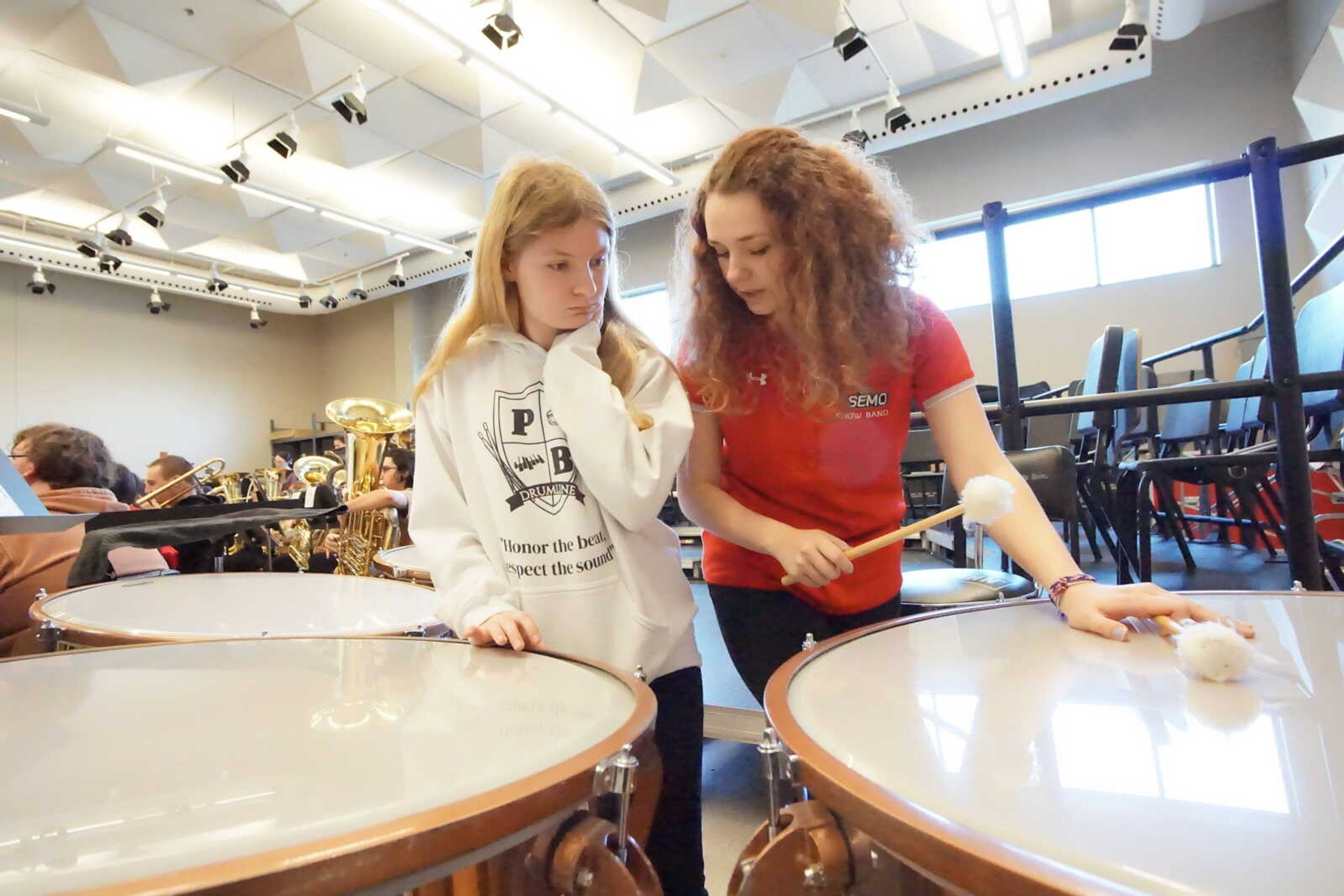 Music performance major Angel Evans teaches high school student how to play timpani music.