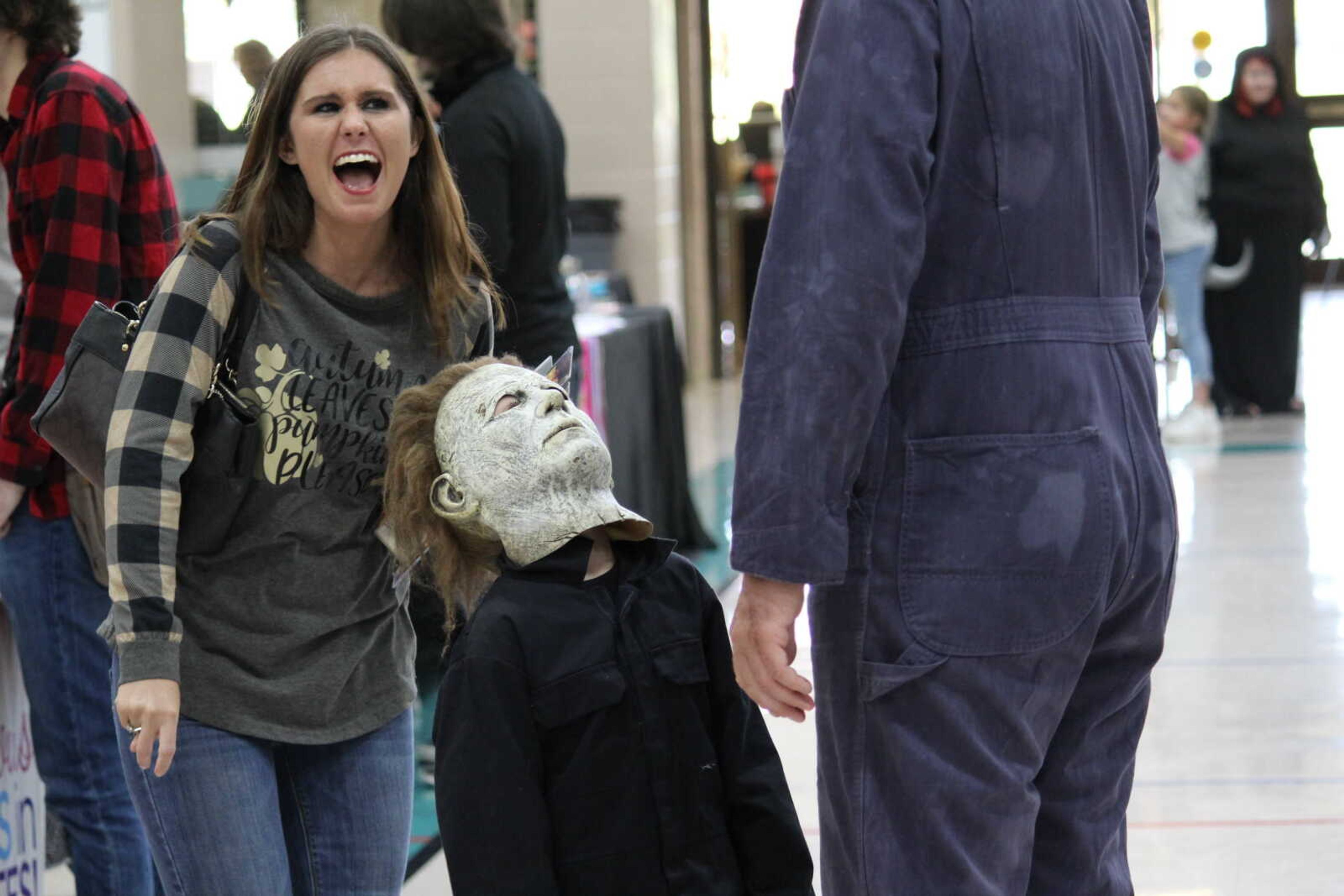 Mini Michael Myers looks to his father Michael Myers from Halloween while his mother laughs during the Cape Fear Con on Oct. 19.