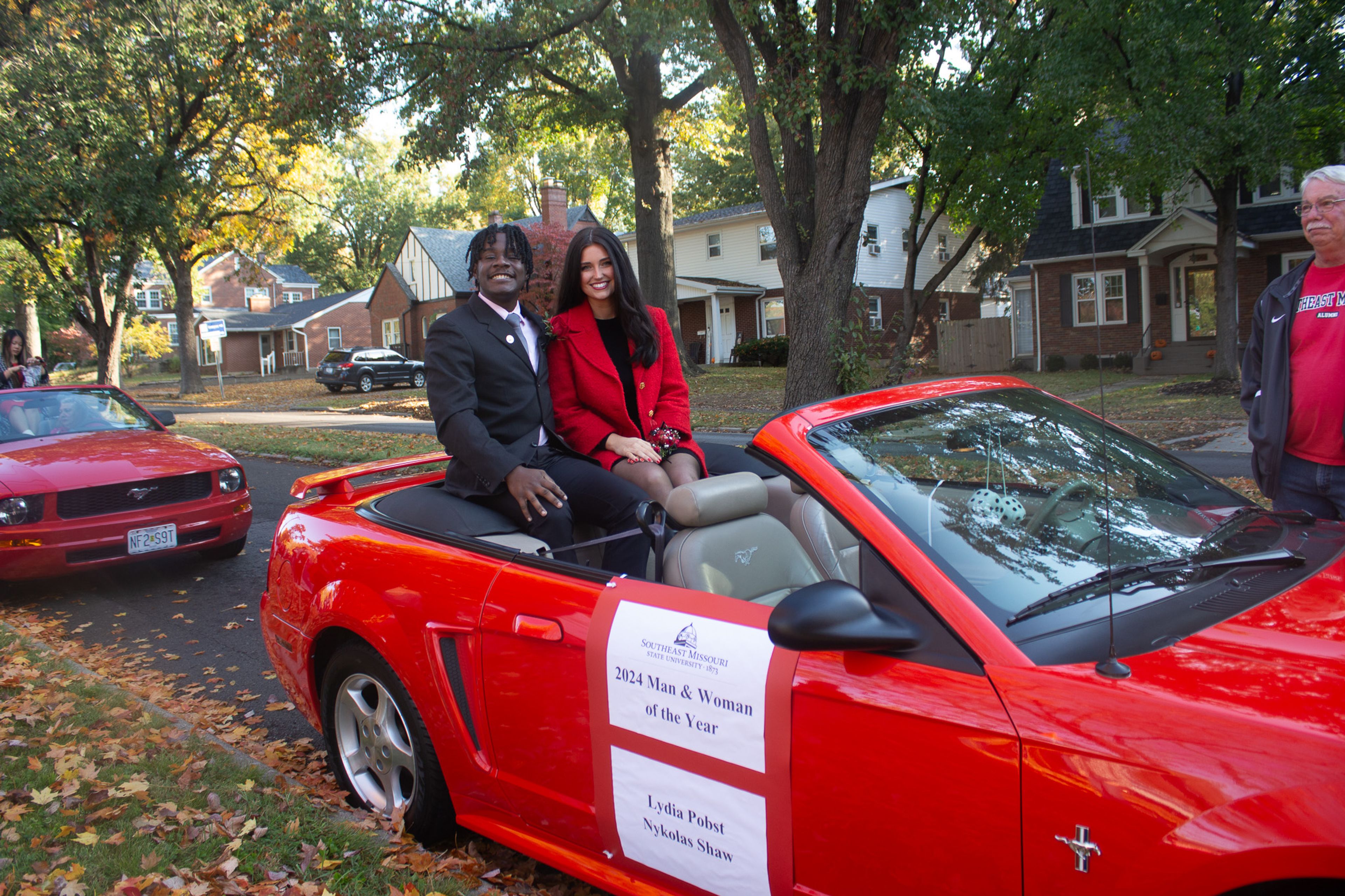 Lydia Pobst and Nykolas Shaw sit in anticipation for the Homecoming Parade to start.