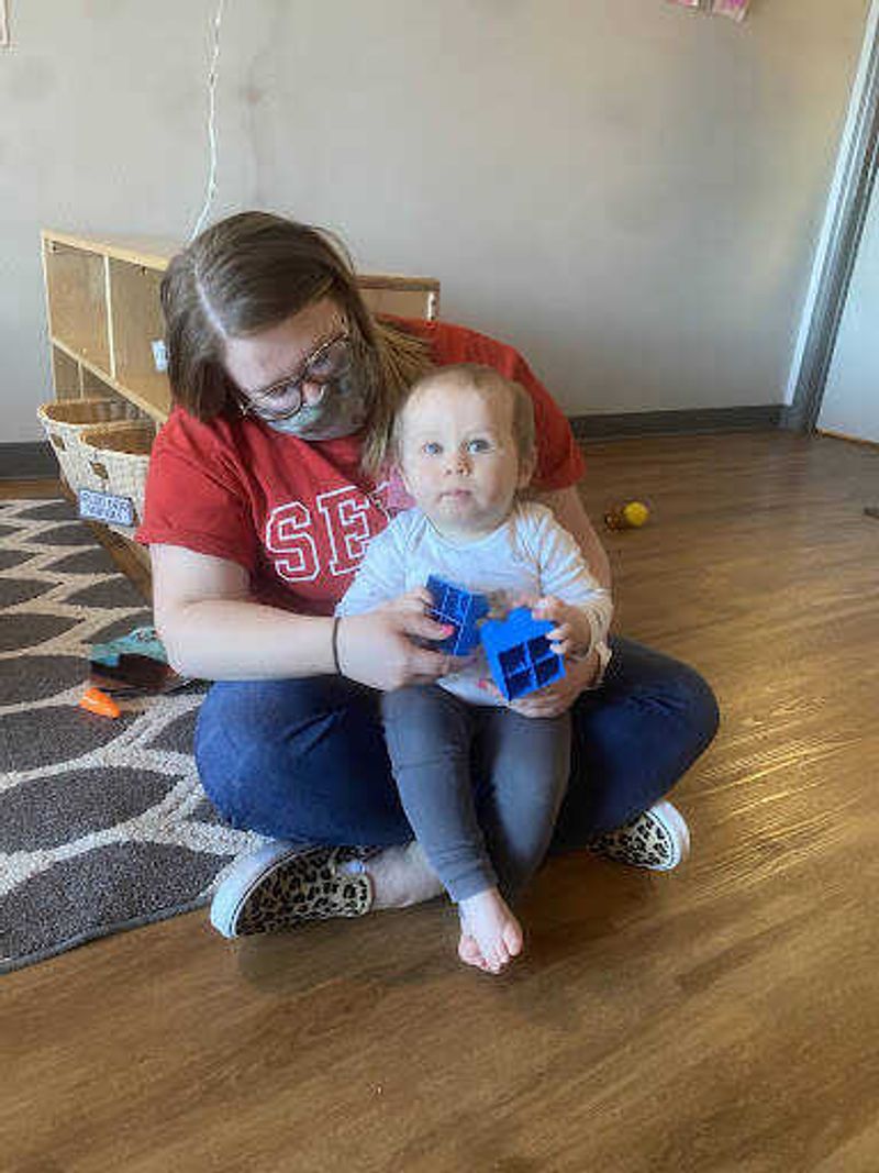 Early education junior Bridgette Berber holds one of her students. She often plays with her students on their level.