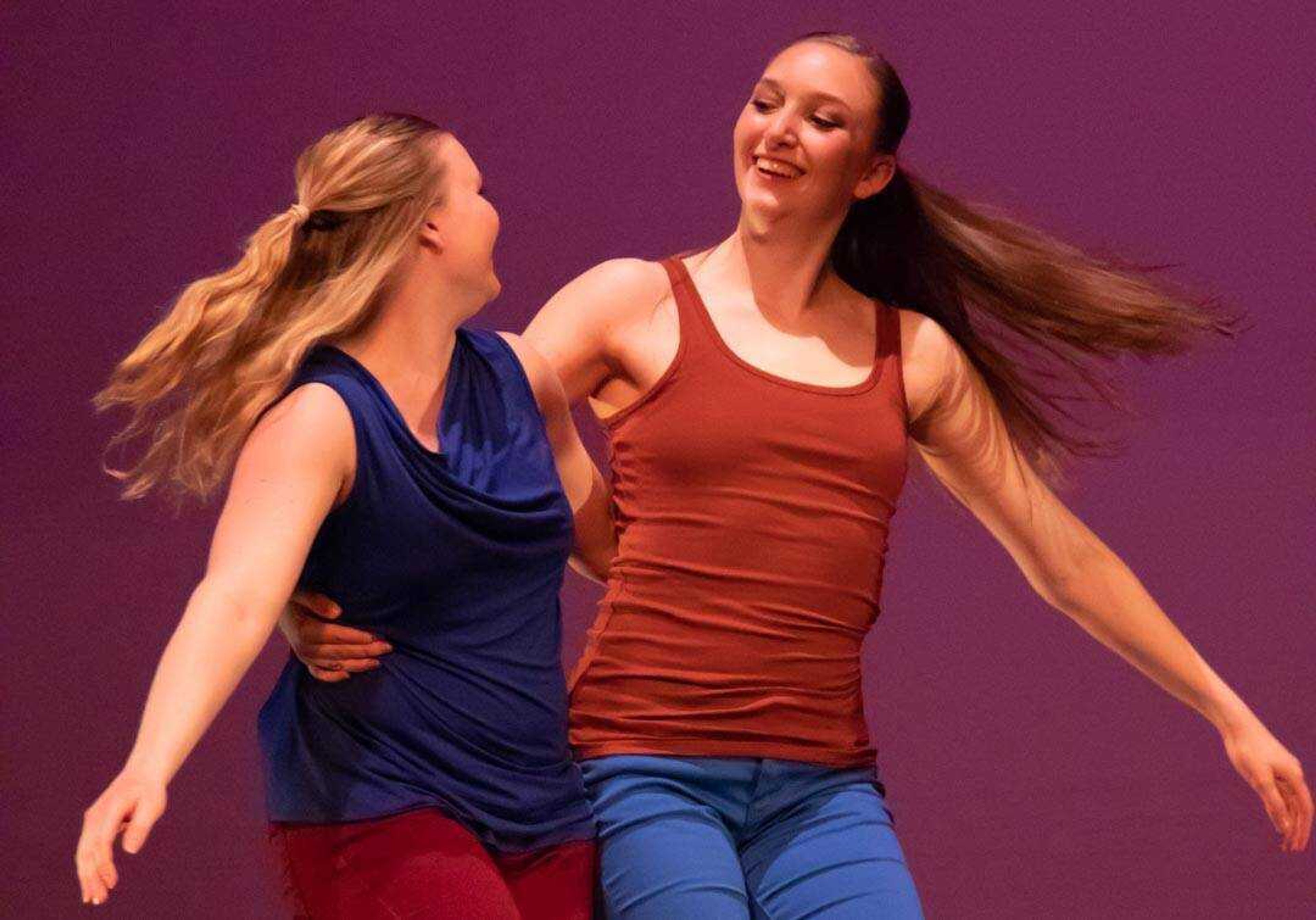 Junior Chloe Galovich (left) and freshman Bailey Bremer smile at each other during "You Go, I Go," choreographed by guest artist Autumn Eckman, during a Spring into Dance dress rehearsal.