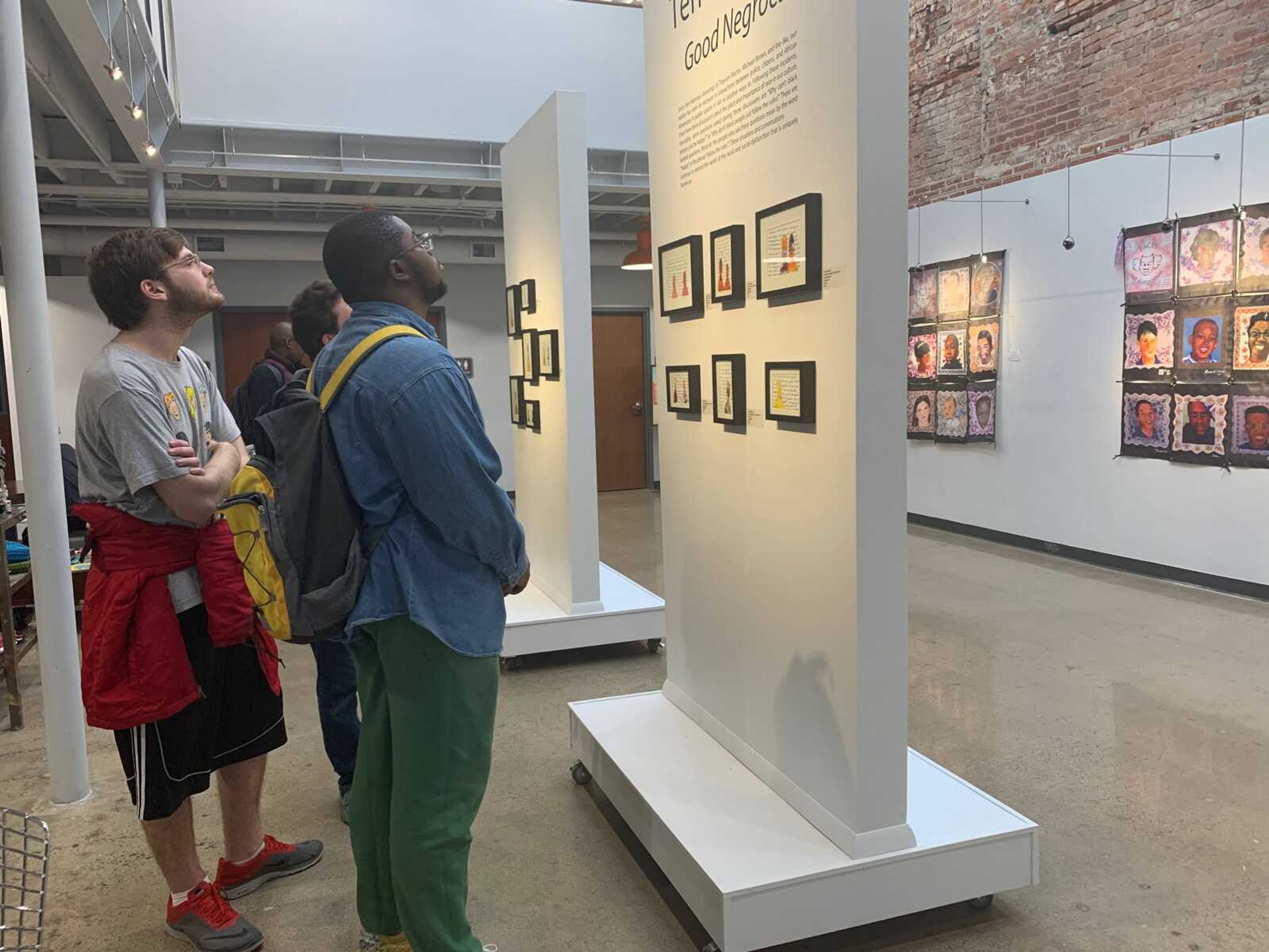Attendees of the event looking at artwork from the artist, Terrell Carter
