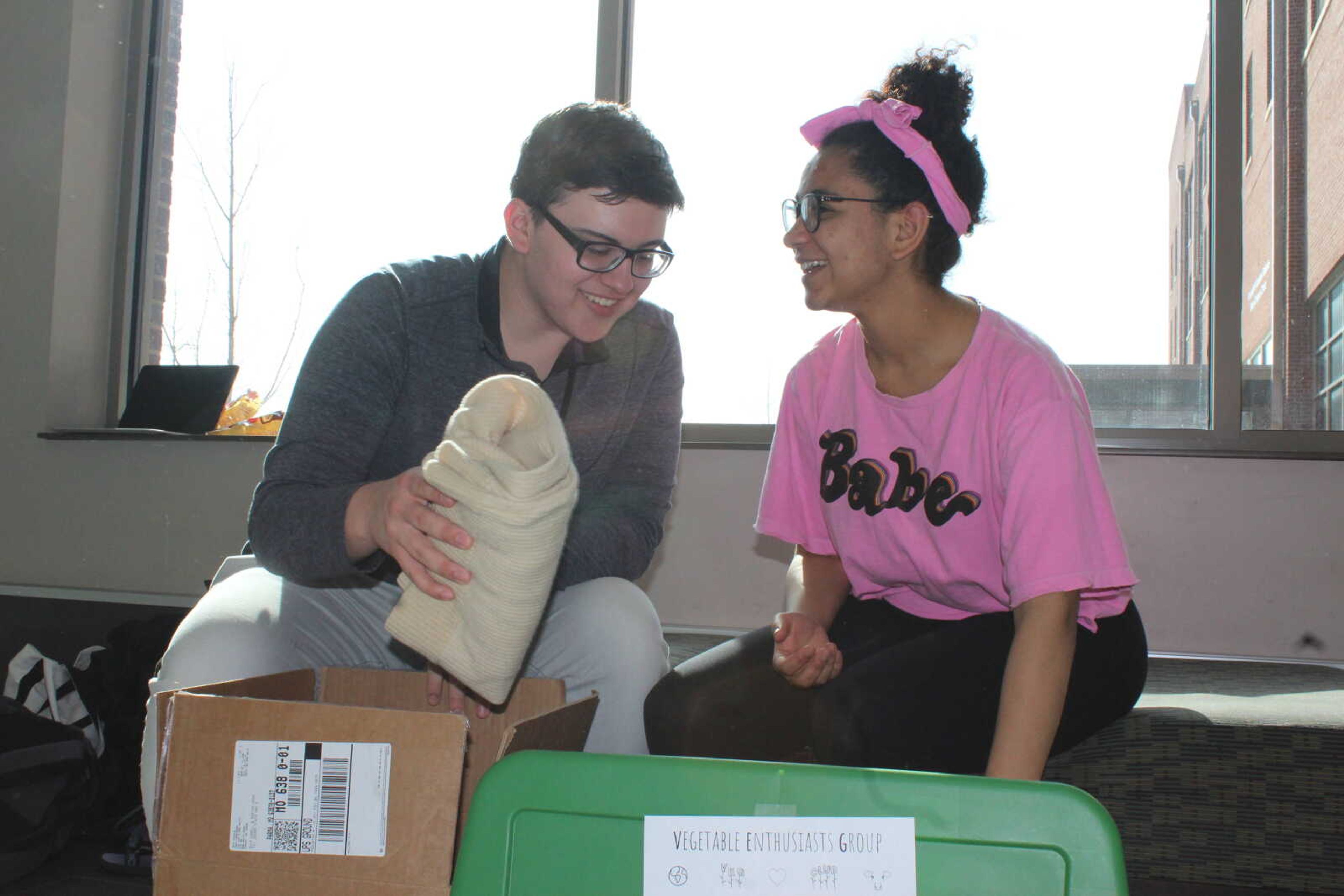 Freshman Mahala Pruett-Pittman, president of the V.E.G. club and Freshman Jacob Welch, another member, fold clothes received from clothing donations for clothing swap March 29.