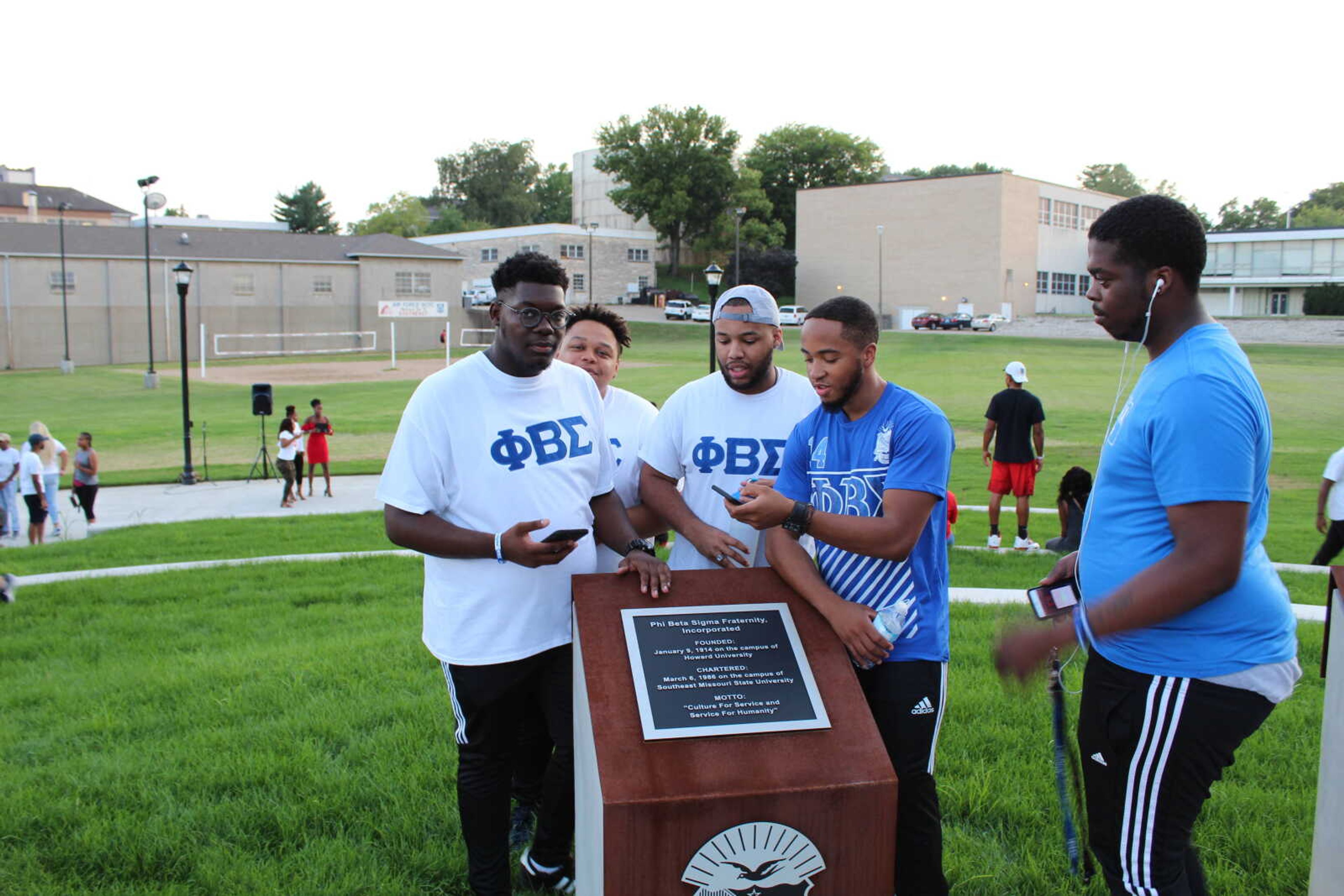 Members of Phi Beta Sigma Fraternity admire the plaque recognizing their organization following the opening ceremony for the NPHC Plaza Aug. 16.